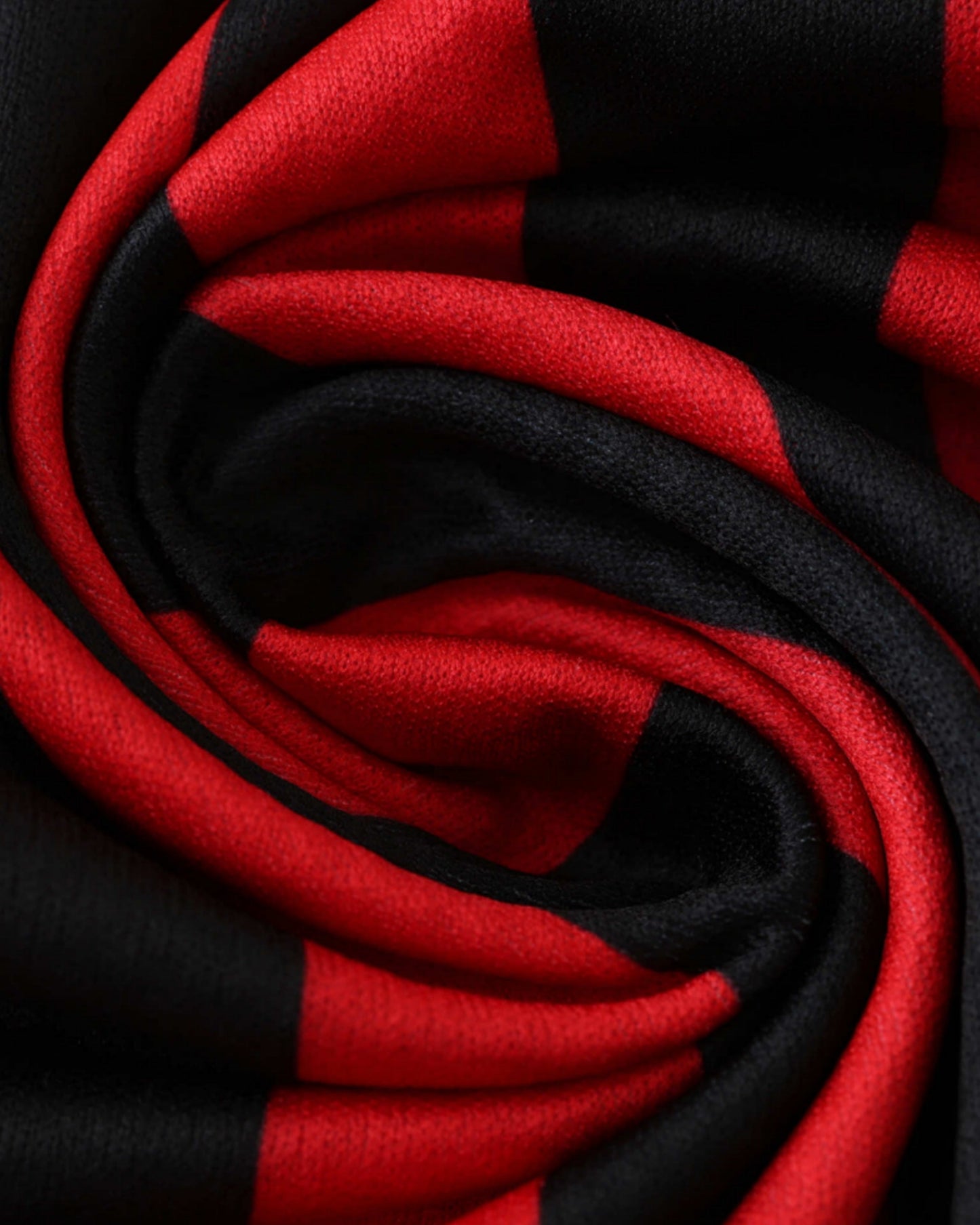 Close-up of the red and black striped fabric on the AC Milan 125th anniversary football jersey