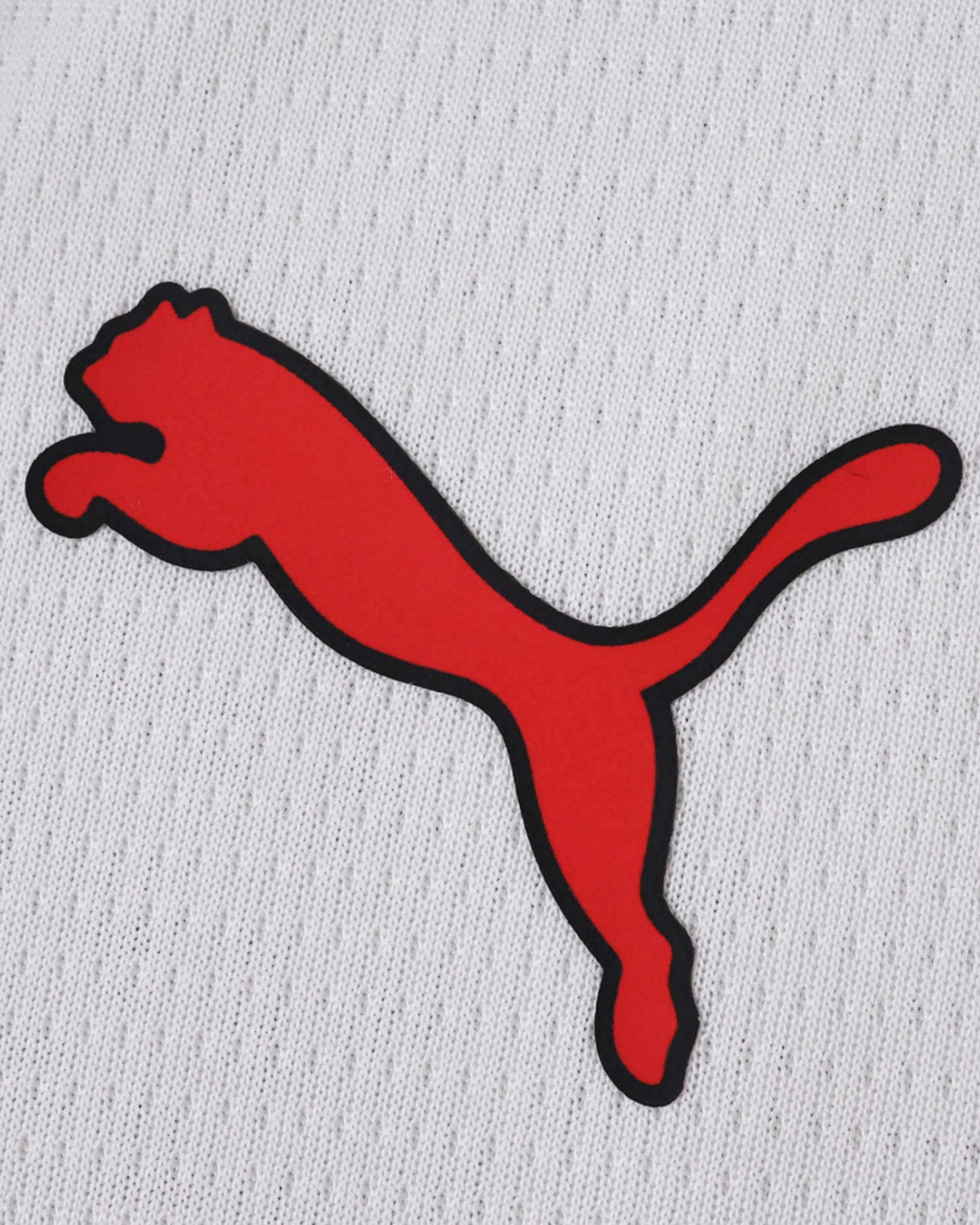 AC Milan away football jersey 2025/26 detail of red Puma logo on white fabric
