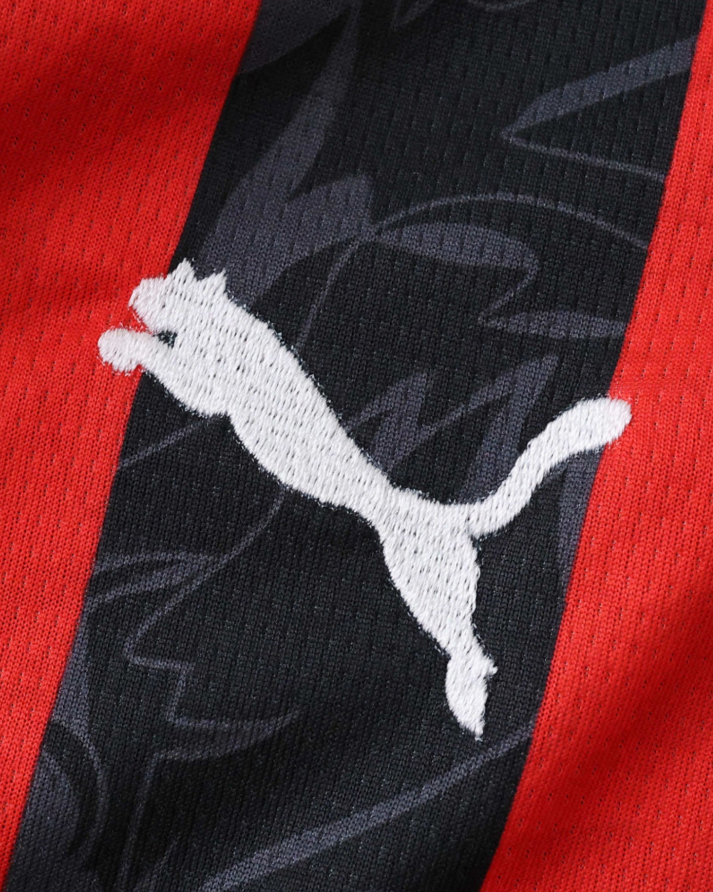 AC Milan home football jersey 2025/26 detail of red black stripes and white Puma logo