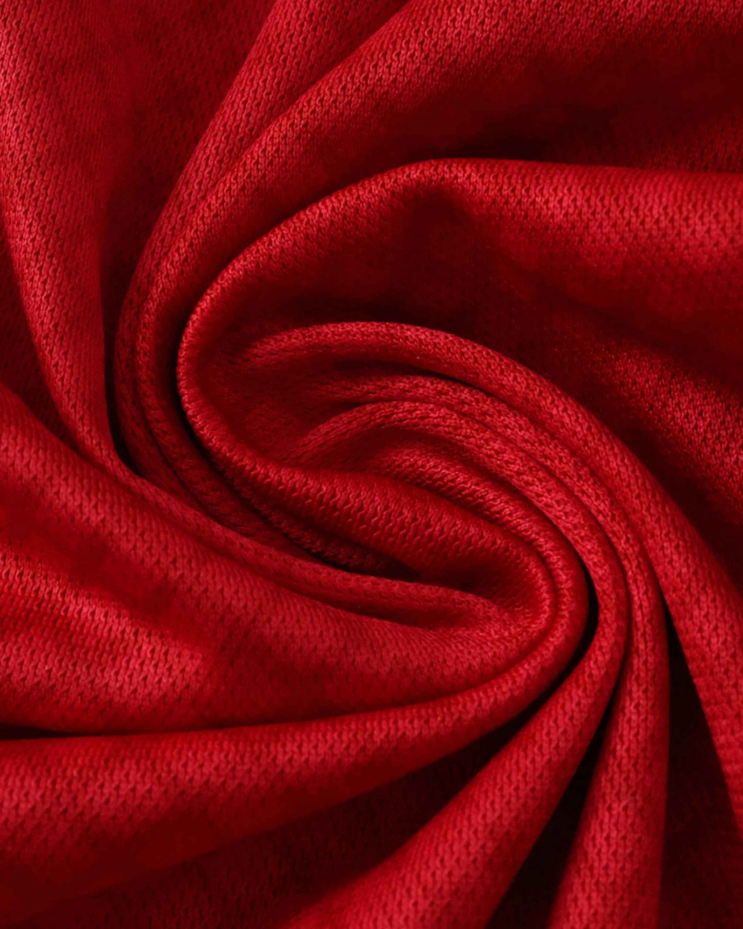 Red textured knit fabric close-up of the Ajax 2025/26 home football jersey