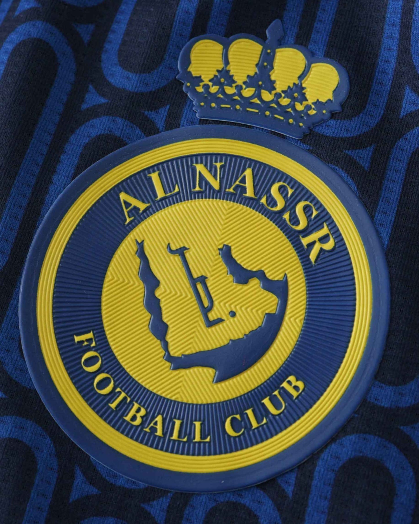 Al Nassr FC crown crest on the navy blue and yellow patterned 2024/25 away football jersey