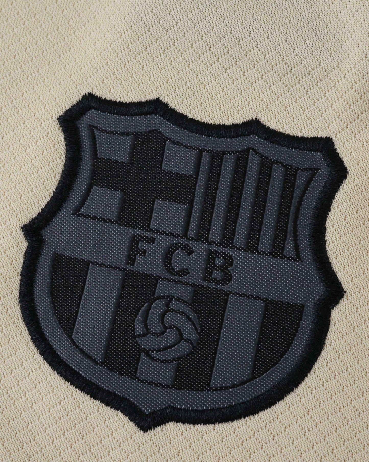 Black FCB crest on the cream Barcelona Away 2025/26 kids football jersey