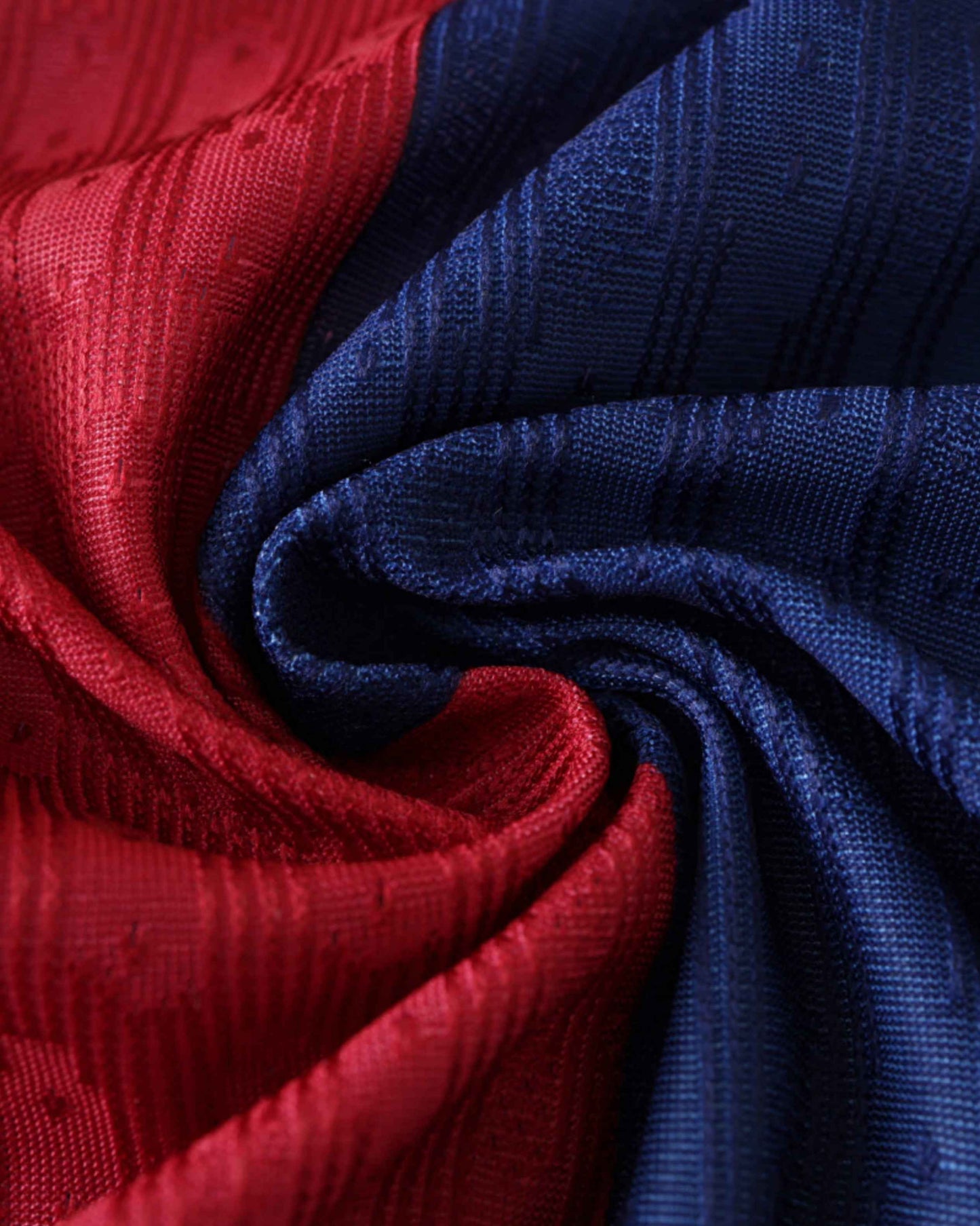 Red and blue fabric with a textured pattern, swirled together.