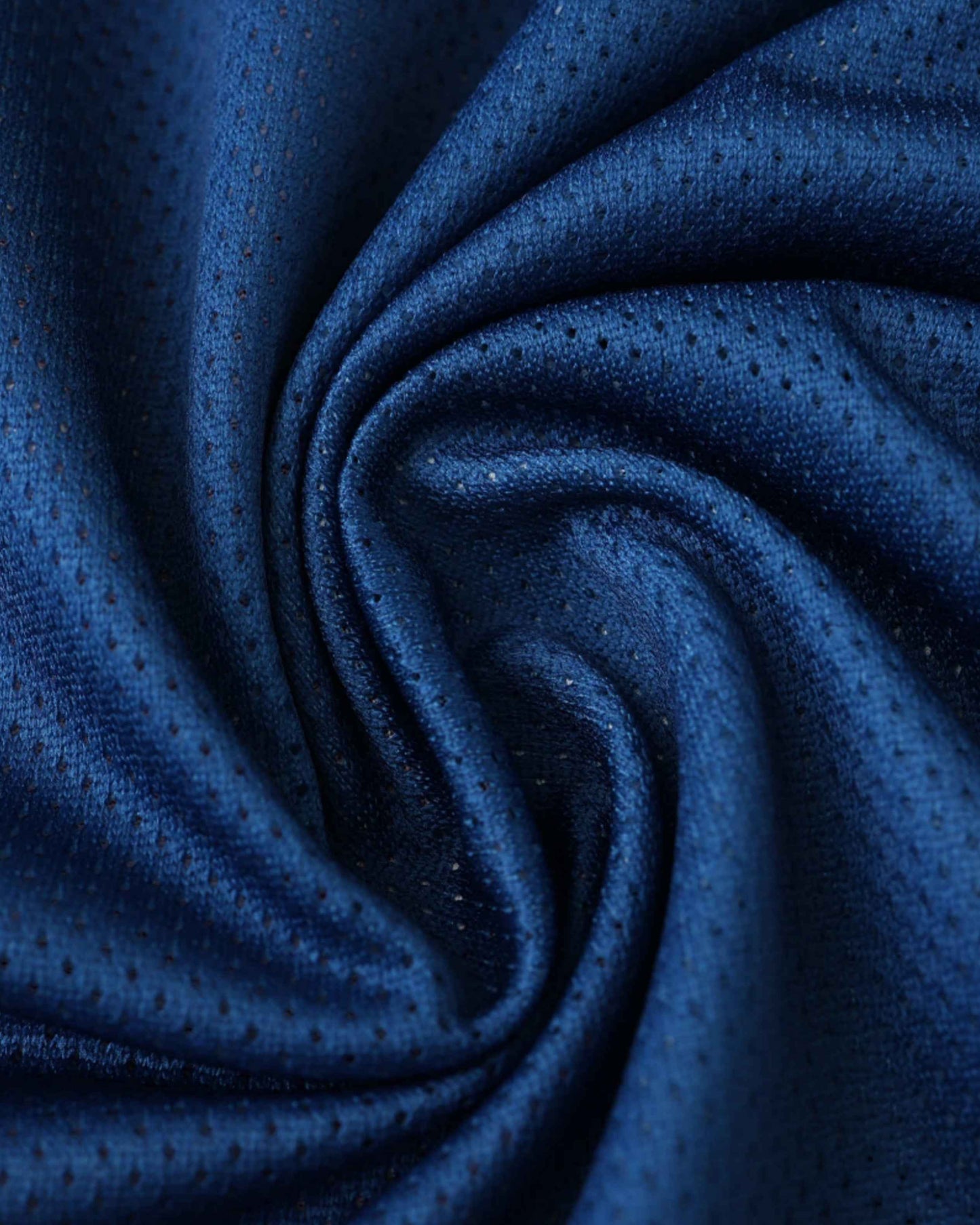 Blue fabric with small perforations, folded in a swirl.