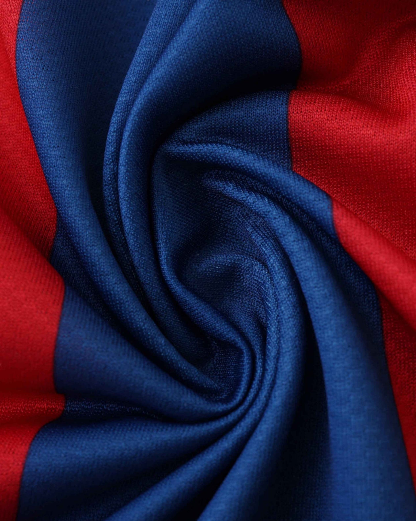 Close-up of a blue and red striped fabric with soft folds.