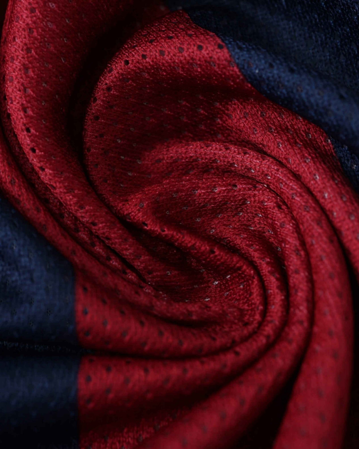 Close-up of a red and blue striped fabric with a textured pattern.