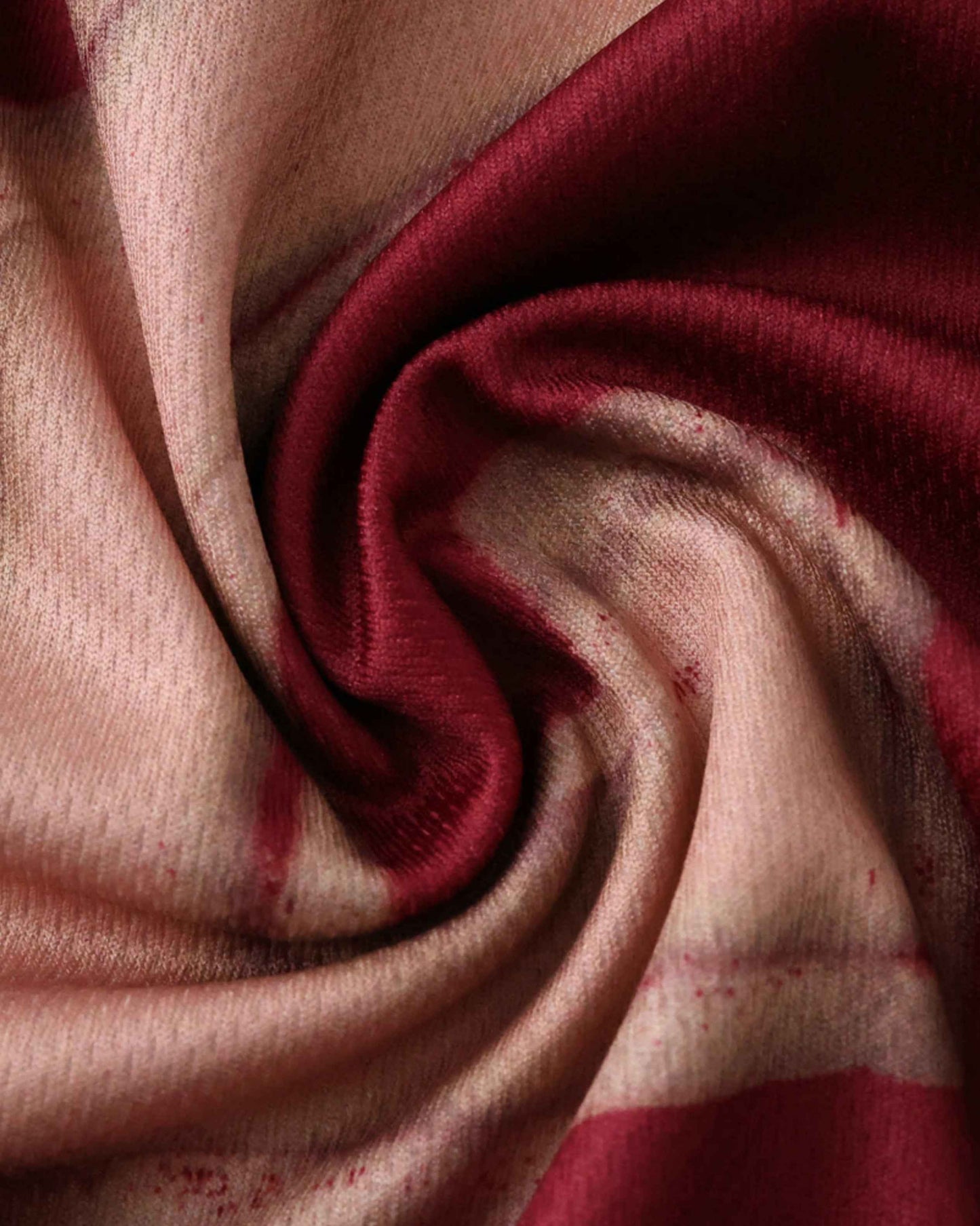 Textured fabric with a maroon and beige abstract pattern.