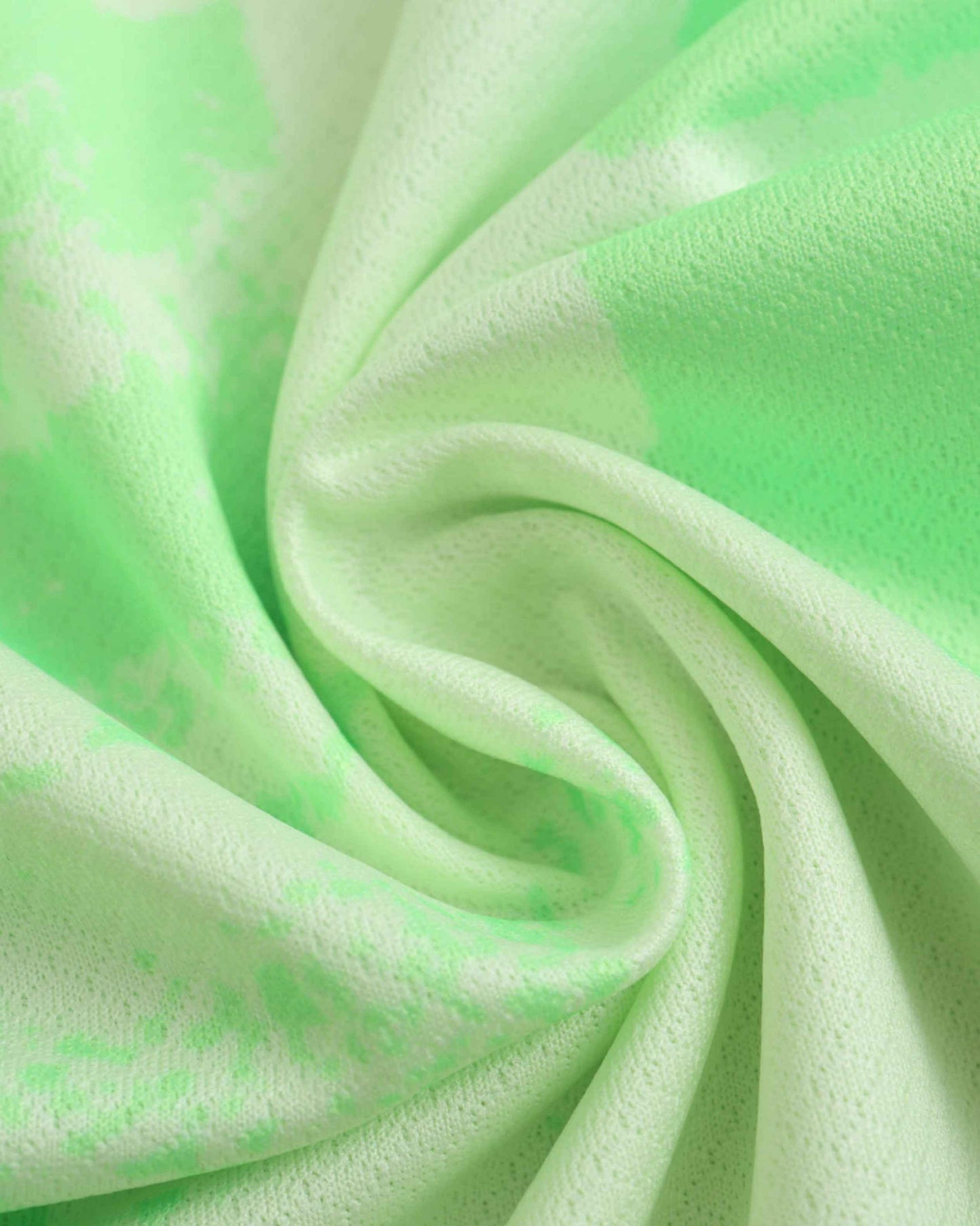 Green tie-dye fabric with a textured knit pattern.
