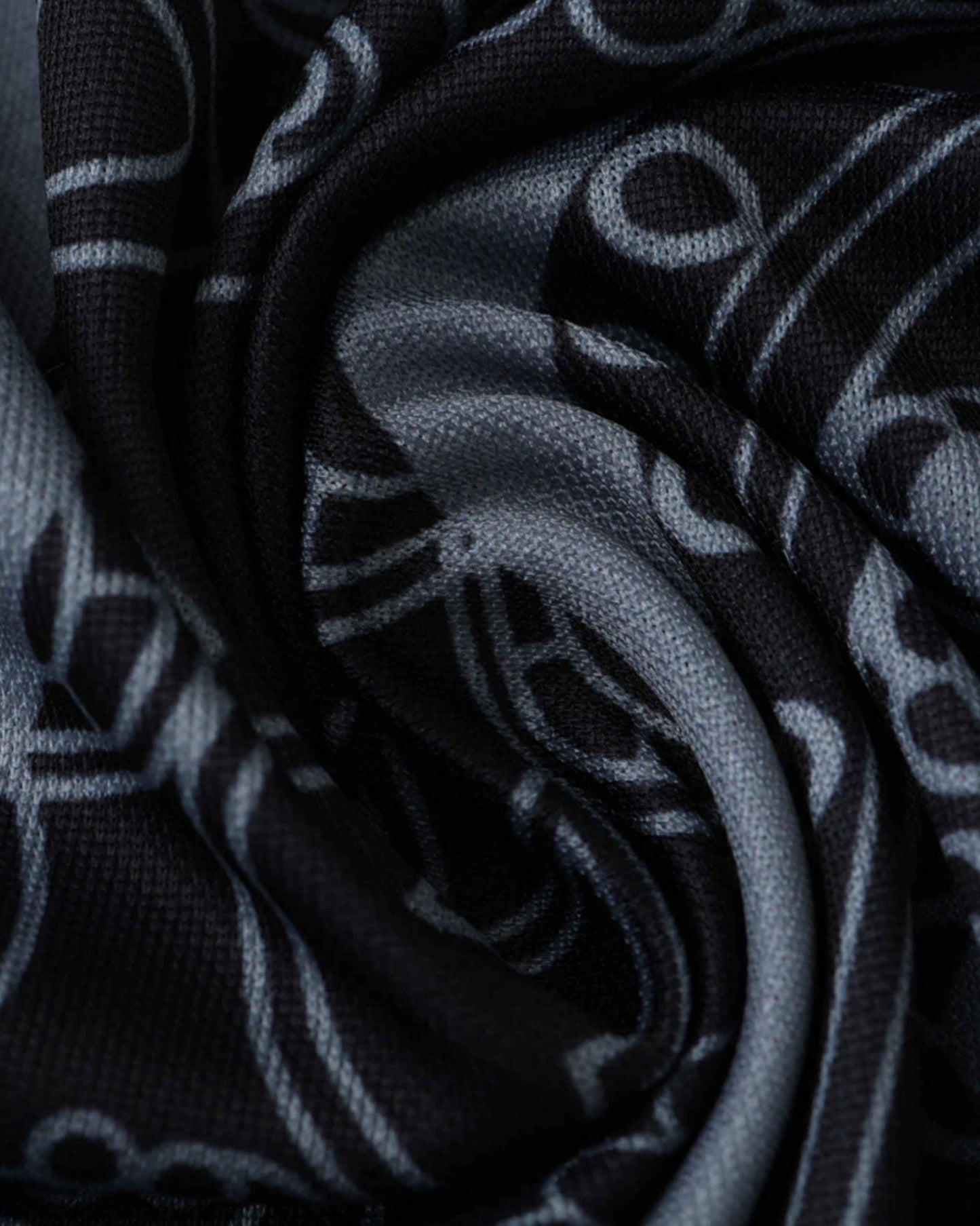 Black and grey fabric with a repeating pattern of circular shapes.