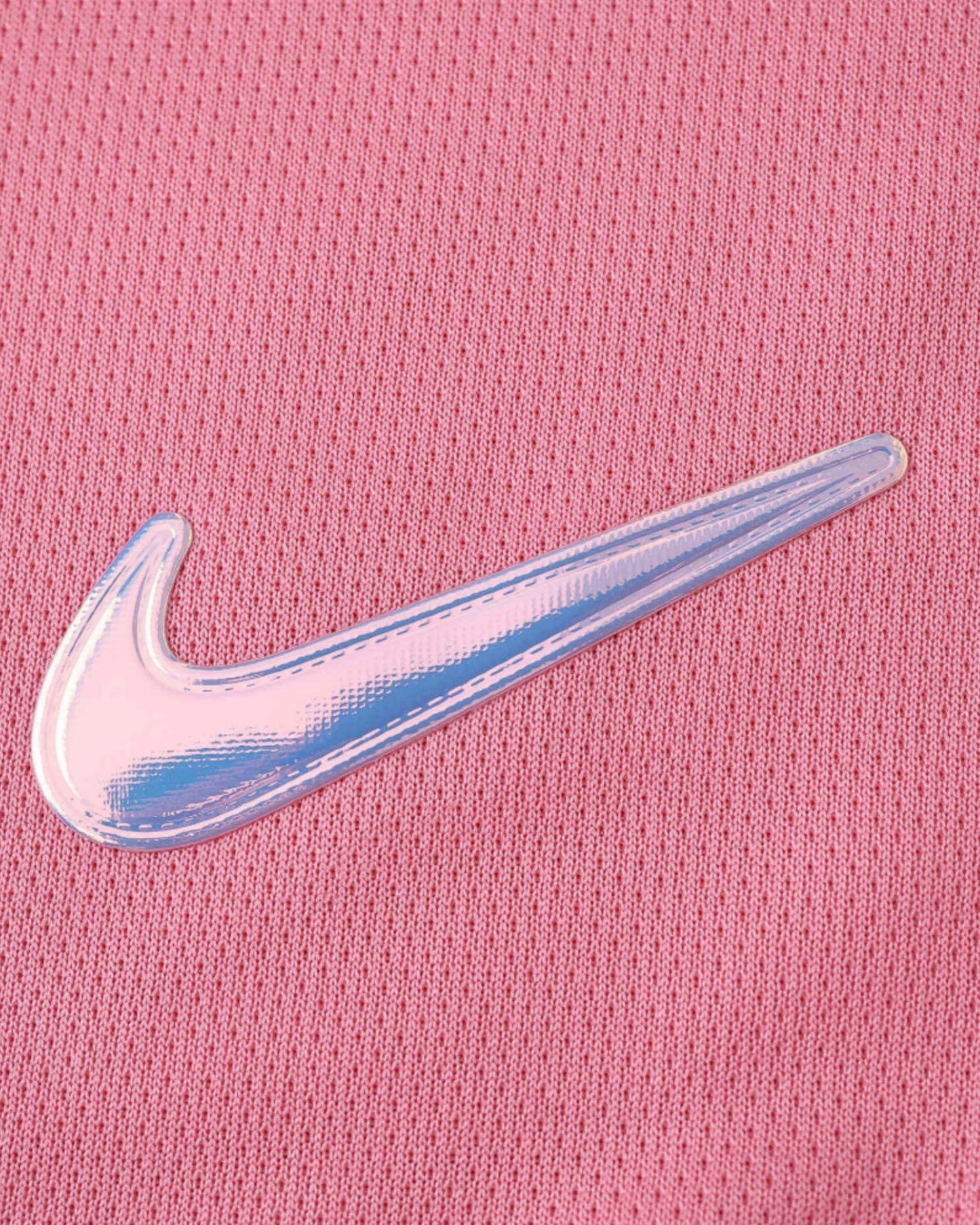 Holographic Nike swoosh on the pink Barcelona x Aurora kids football jersey