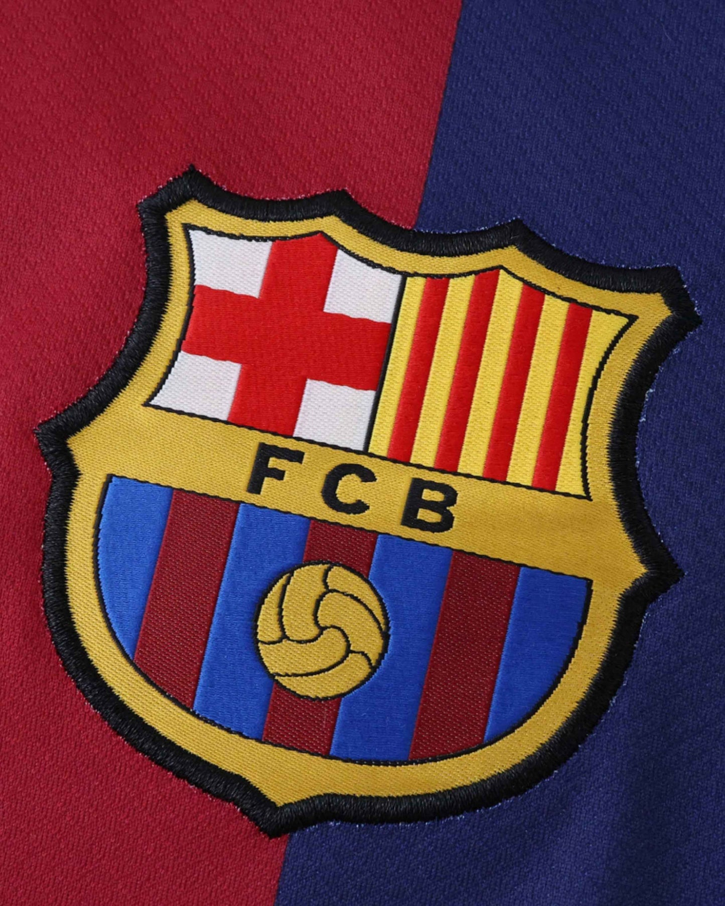 Close-up of the FC Barcelona crest on a red and blue shirt.