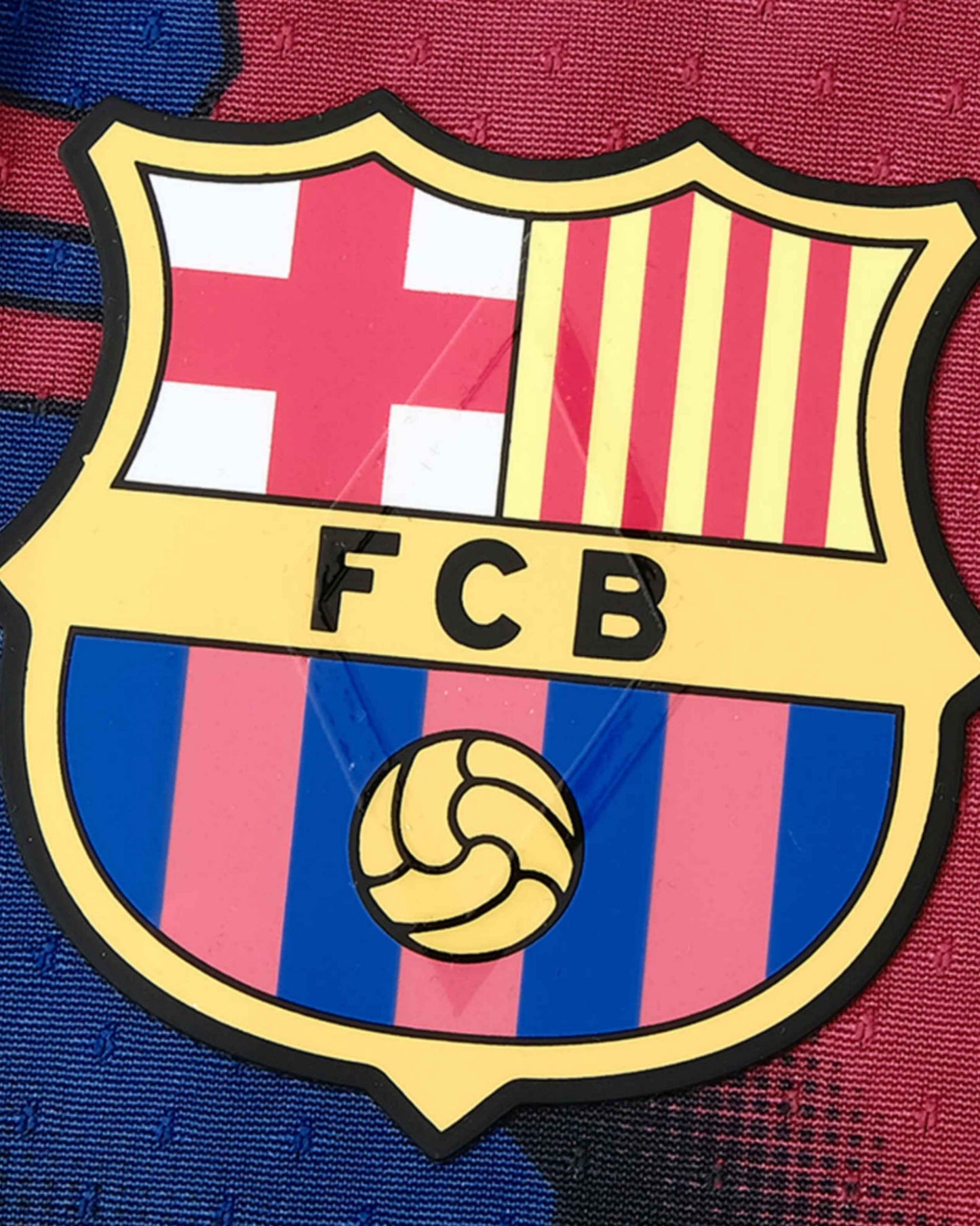 A close-up of the FC Barcelona crest with red, yellow, blue, and white sections.