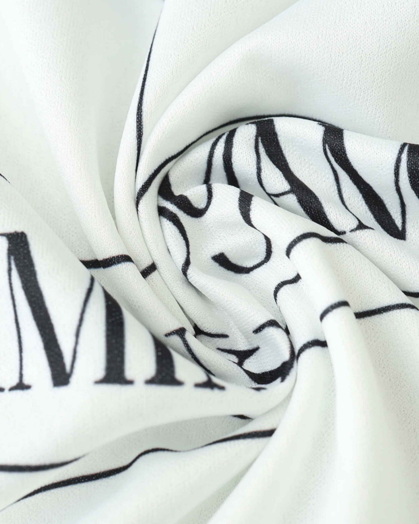 White fabric with black lettering, possibly part of a soccer jersey.