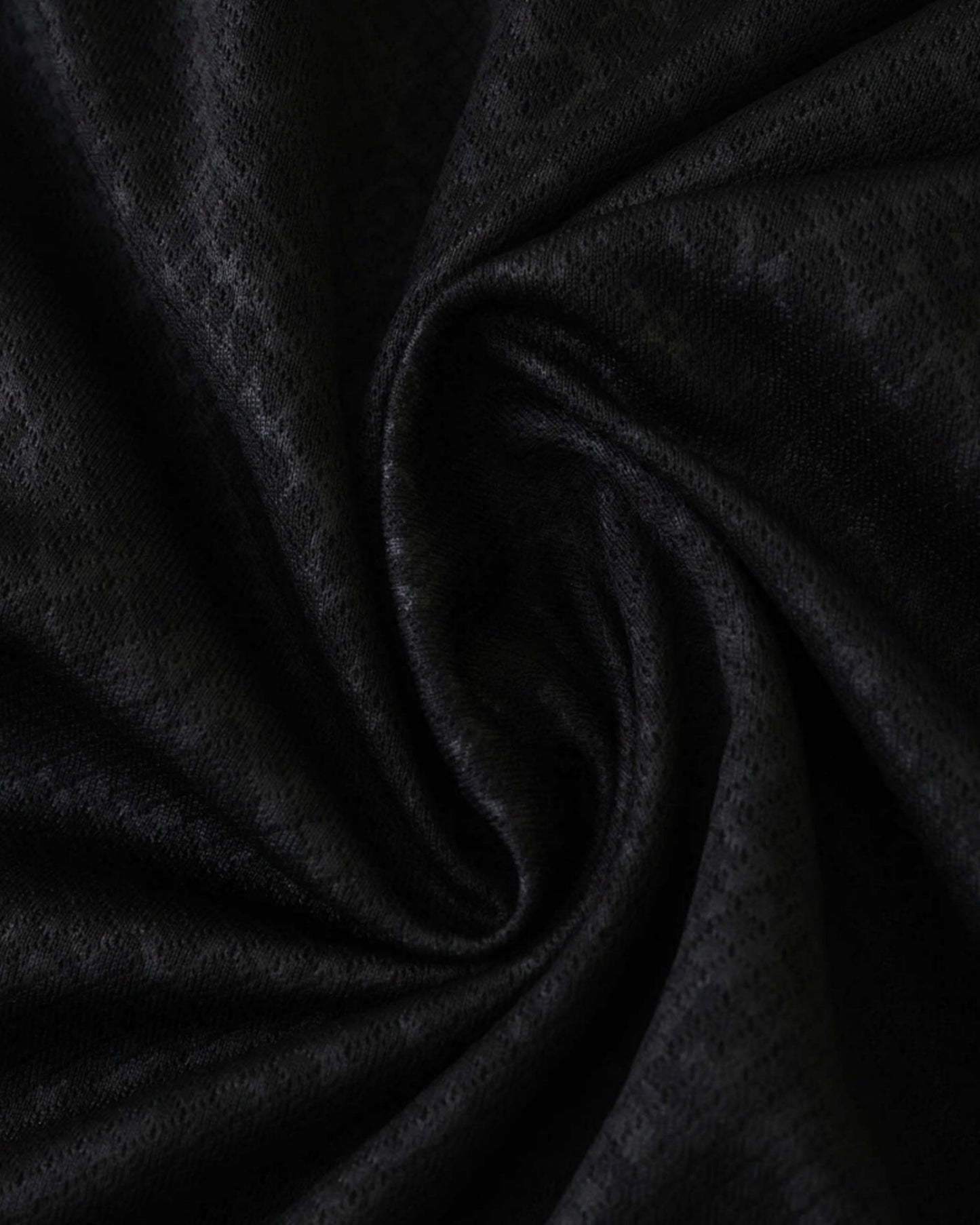 Black textured diamond-pattern fabric of the Barcelona x Mamba football jersey 2025/26