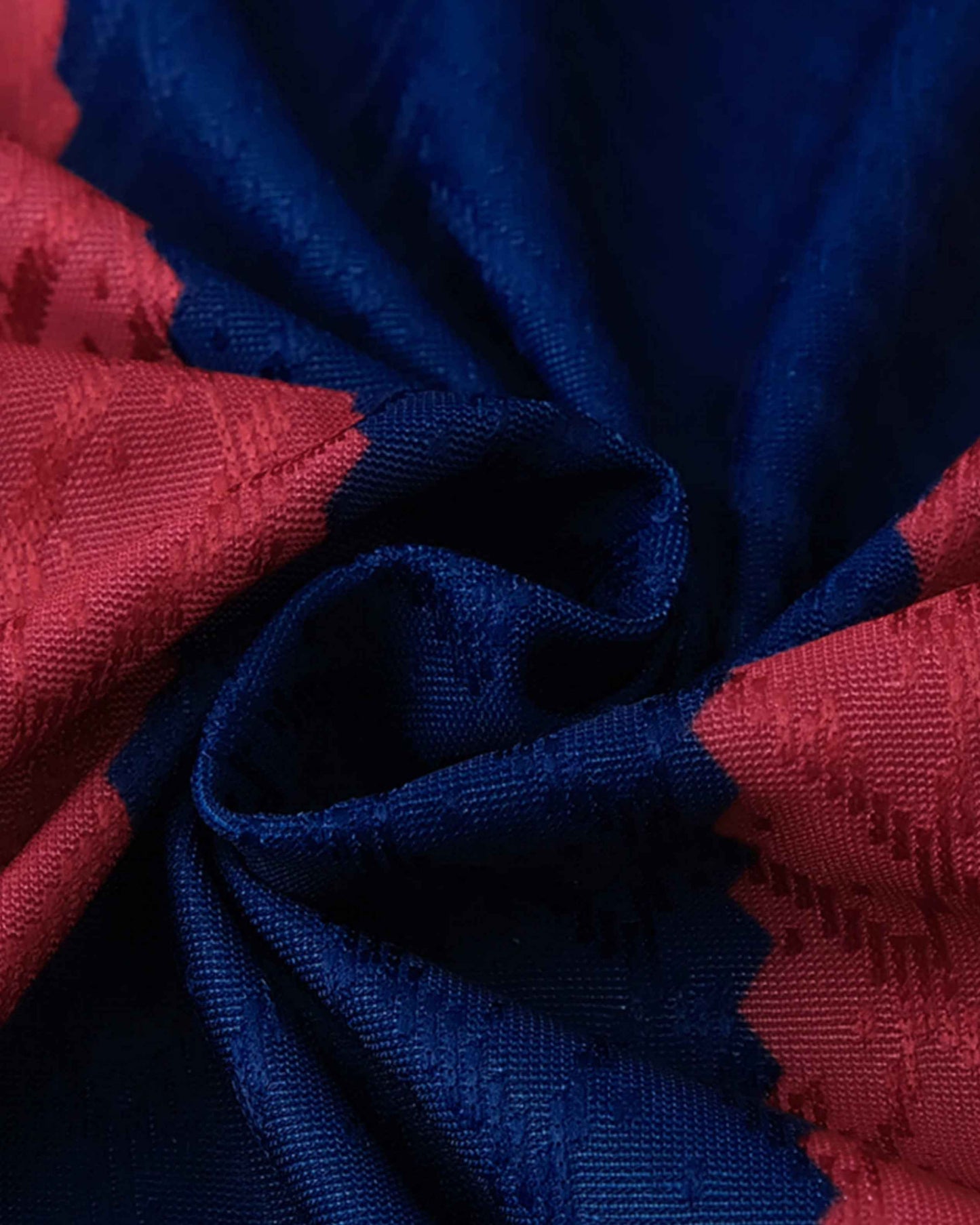 A close-up of a red and blue textured fabric with a subtle pattern.