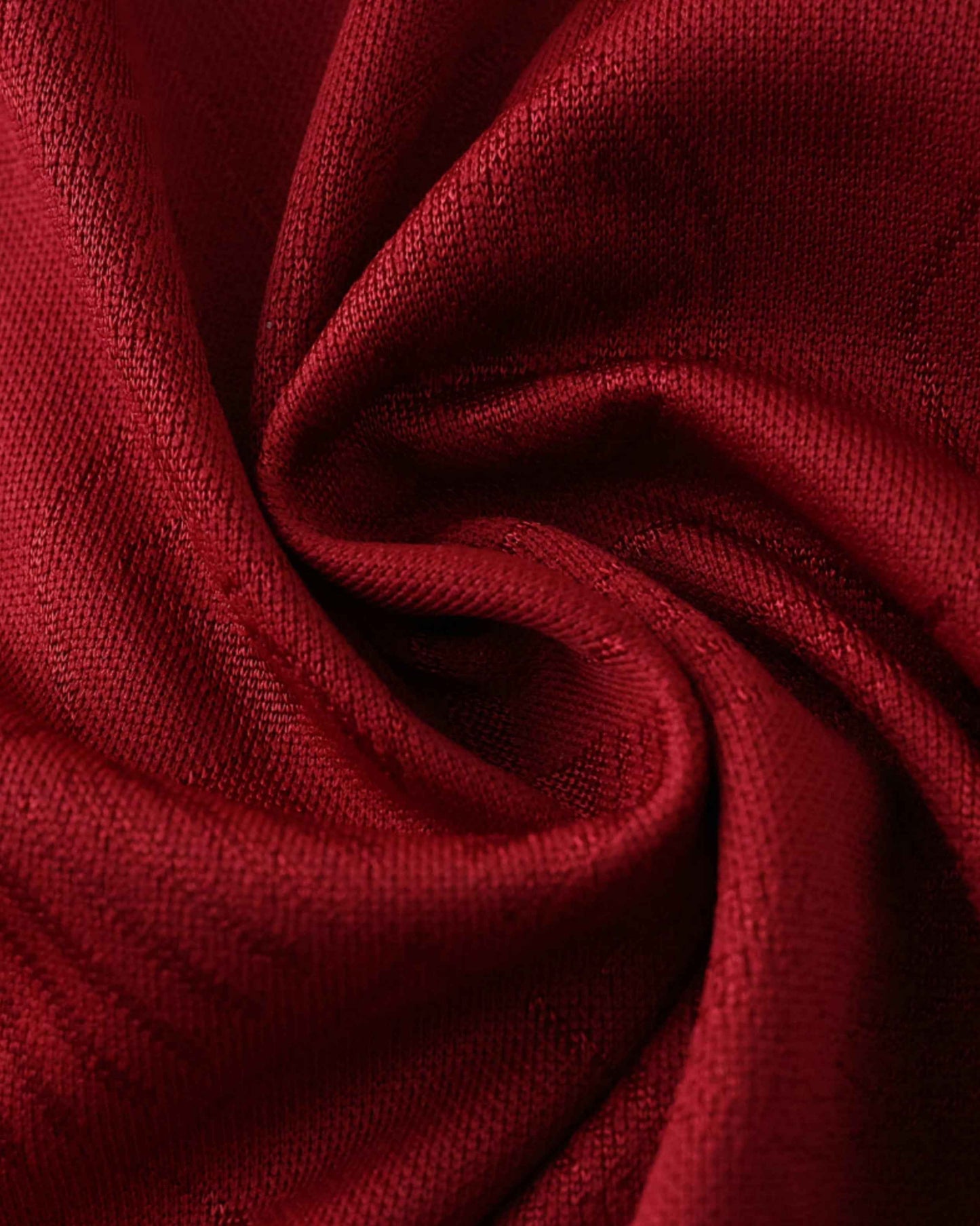 Red fabric with a textured knit pattern, folded into soft pleats.