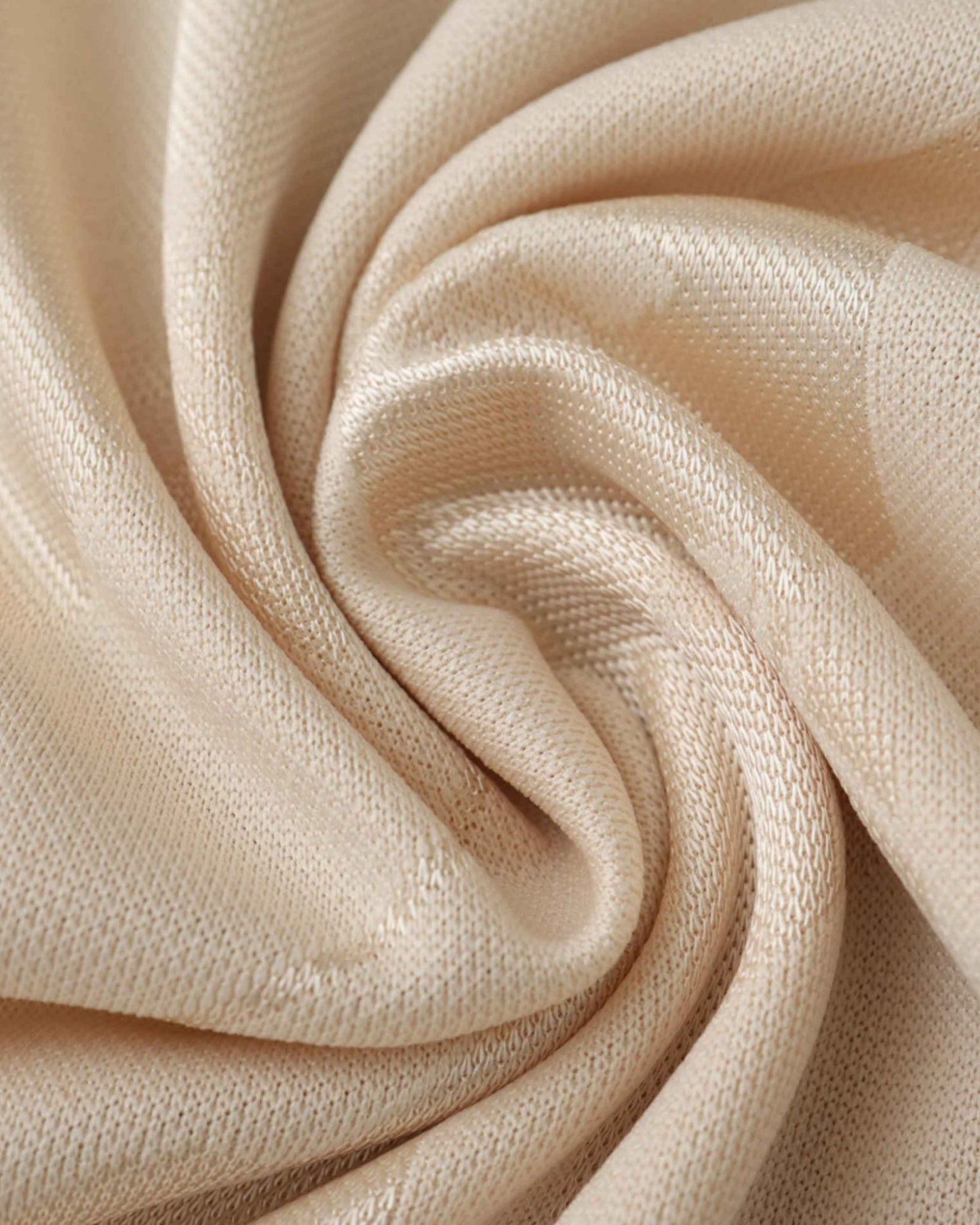 A beige knit fabric is draped in soft folds.