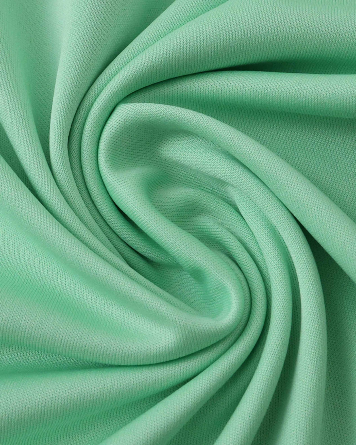 A close-up shot of a mint green fabric with a subtle knit texture.