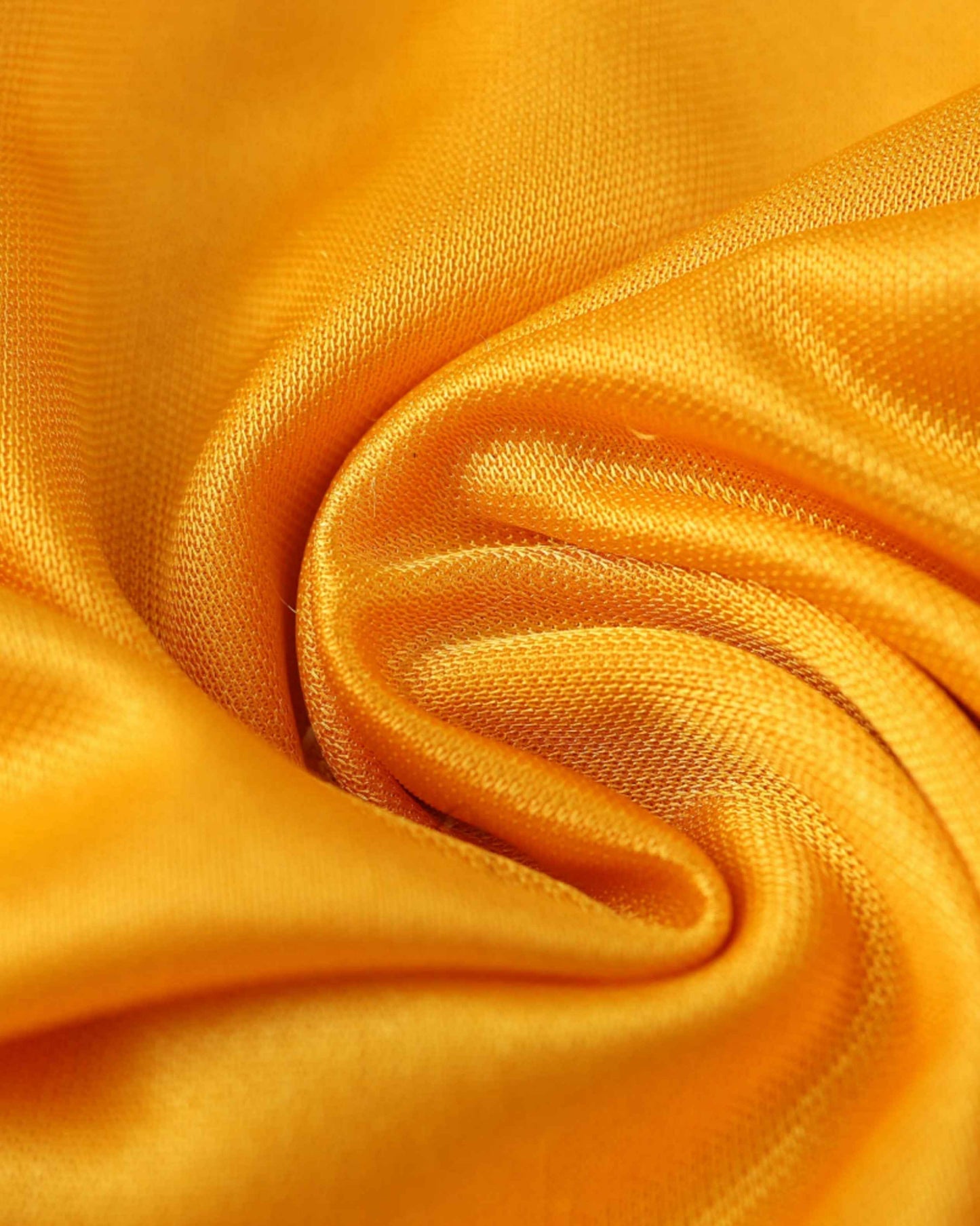 Orange fabric with a textured weave, folded into soft pleats.