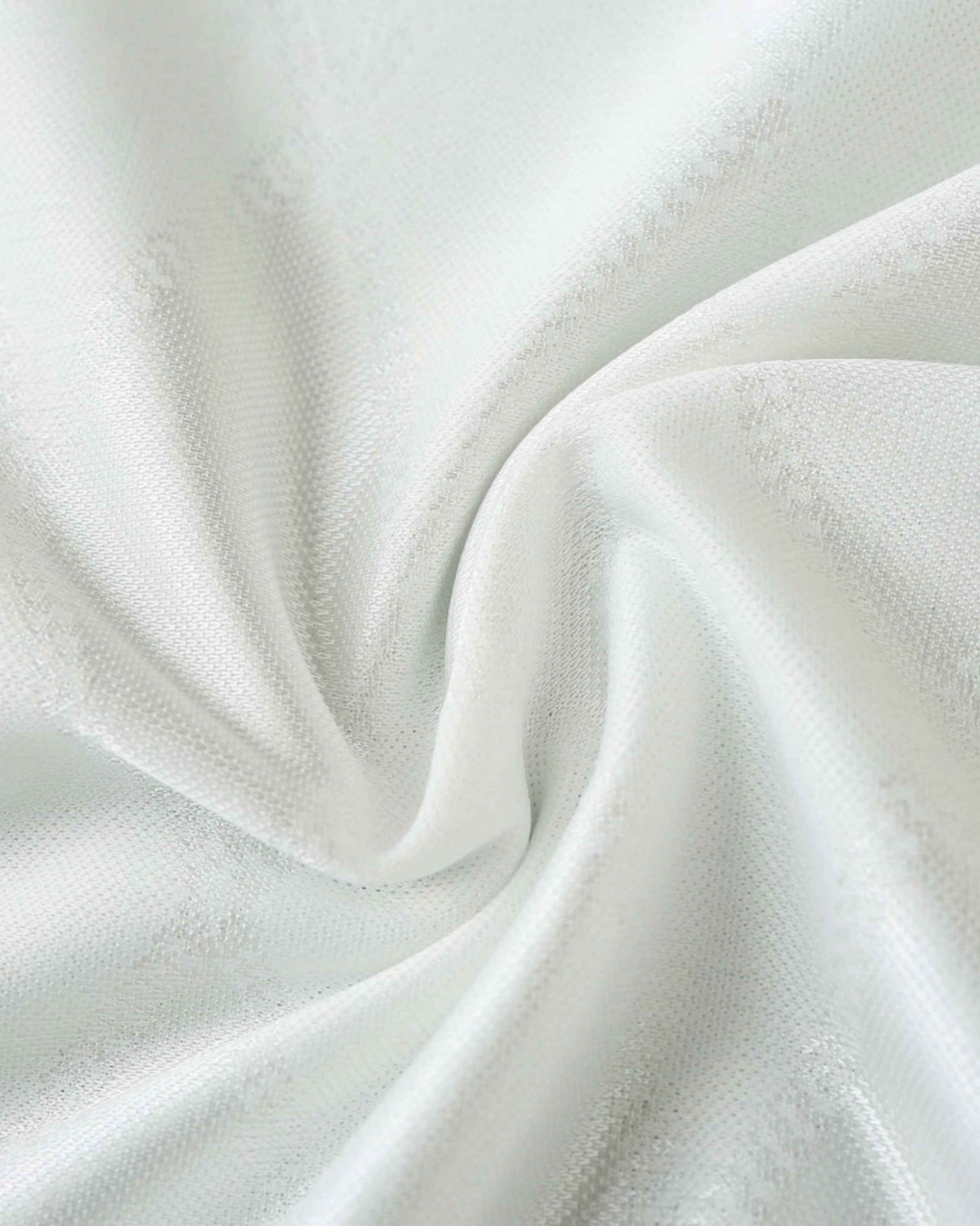 White fabric with a subtle textured pattern, draped in soft folds.