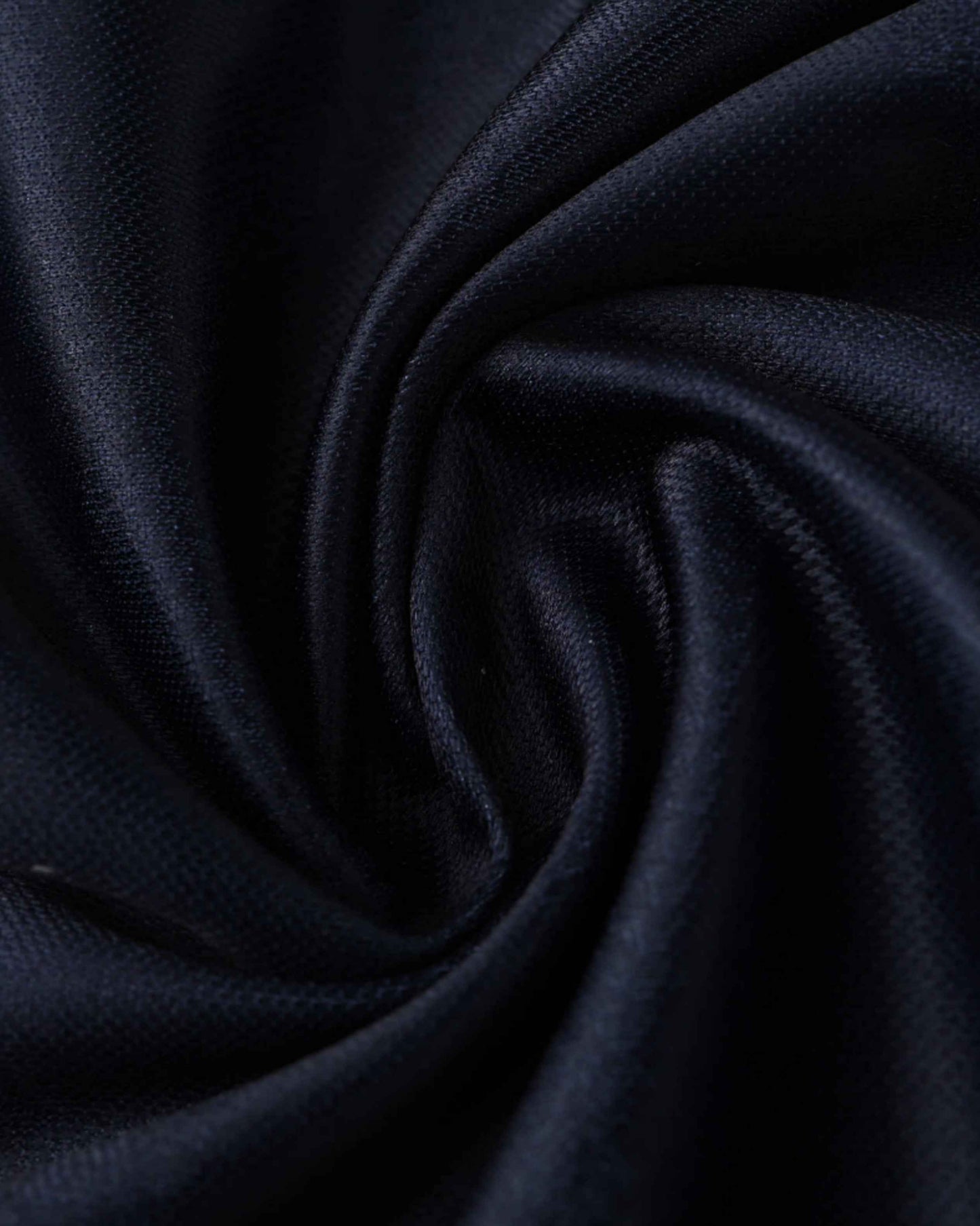 Dark blue textured fabric with folds and creases.
