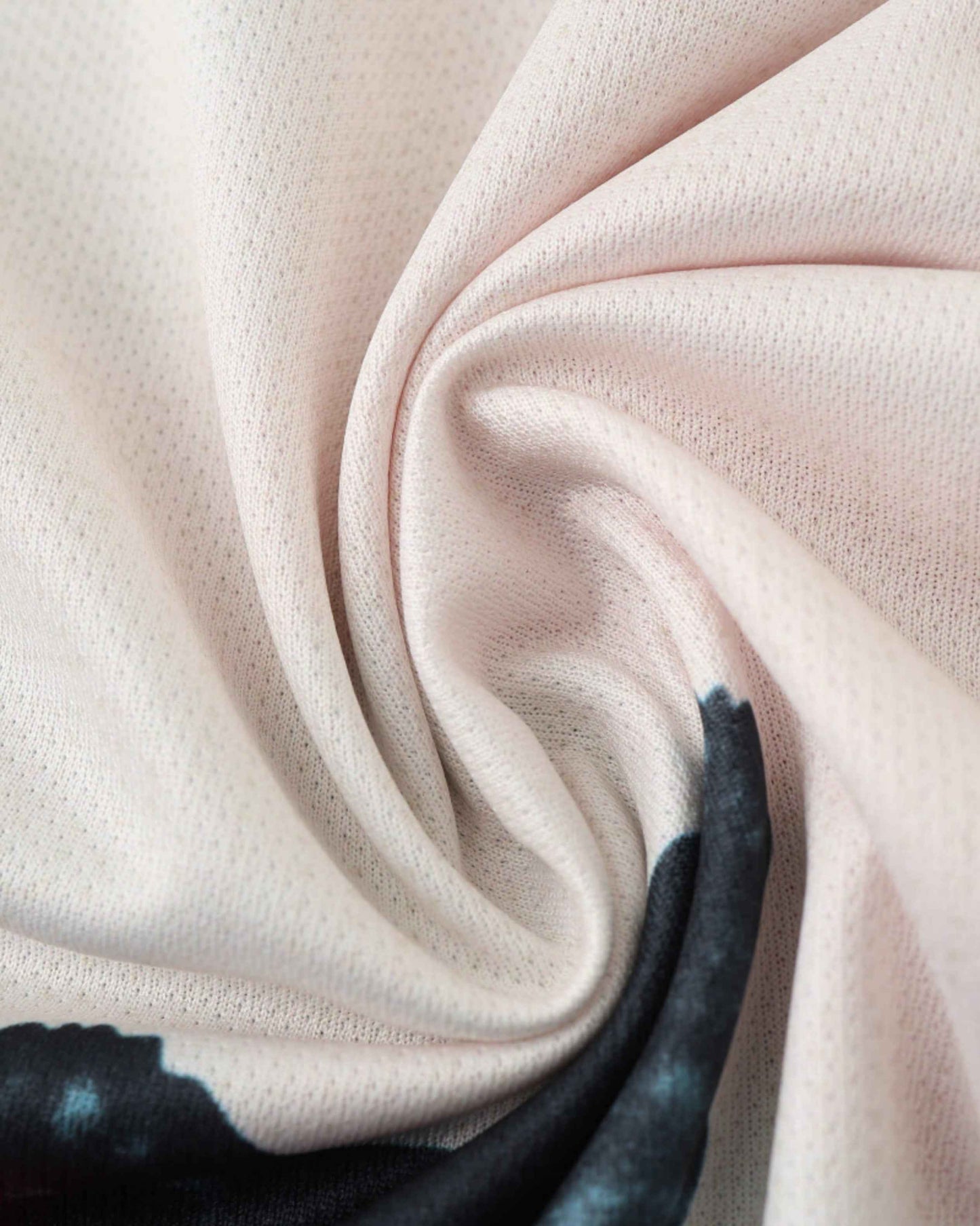 A close-up of a light pink soccer jersey with a subtle textured pattern.