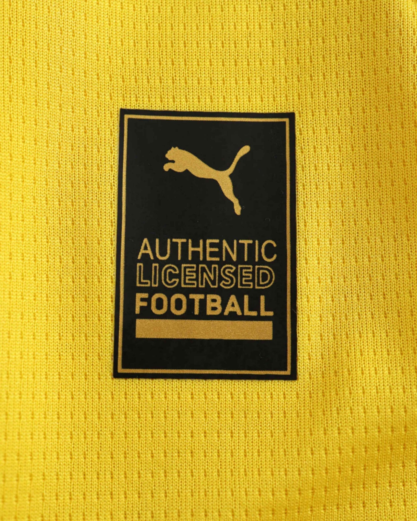 Yellow football jersey with a black and gold Puma authentic licensed football tag.