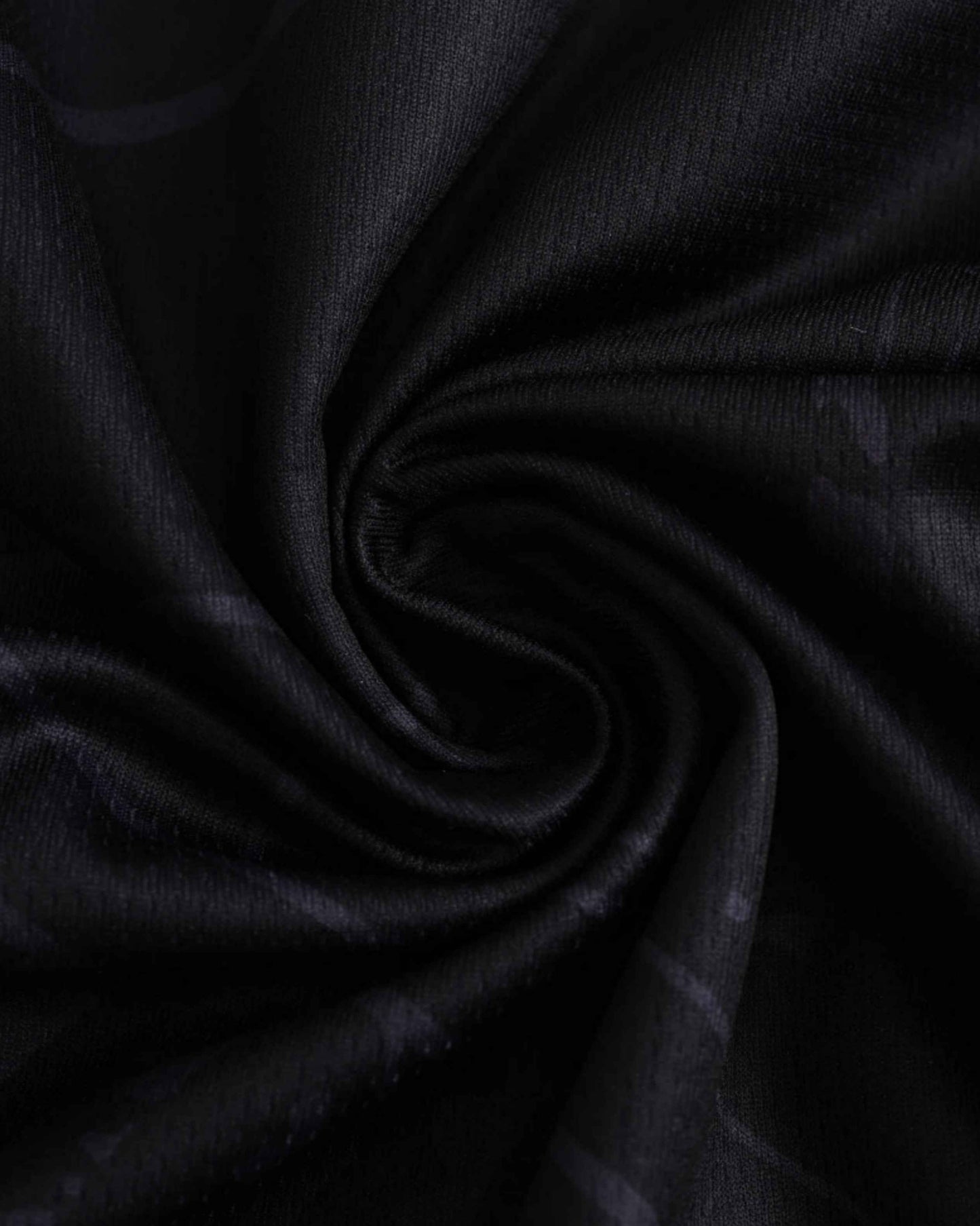 Black fabric with a subtle pattern, draped in a swirl.