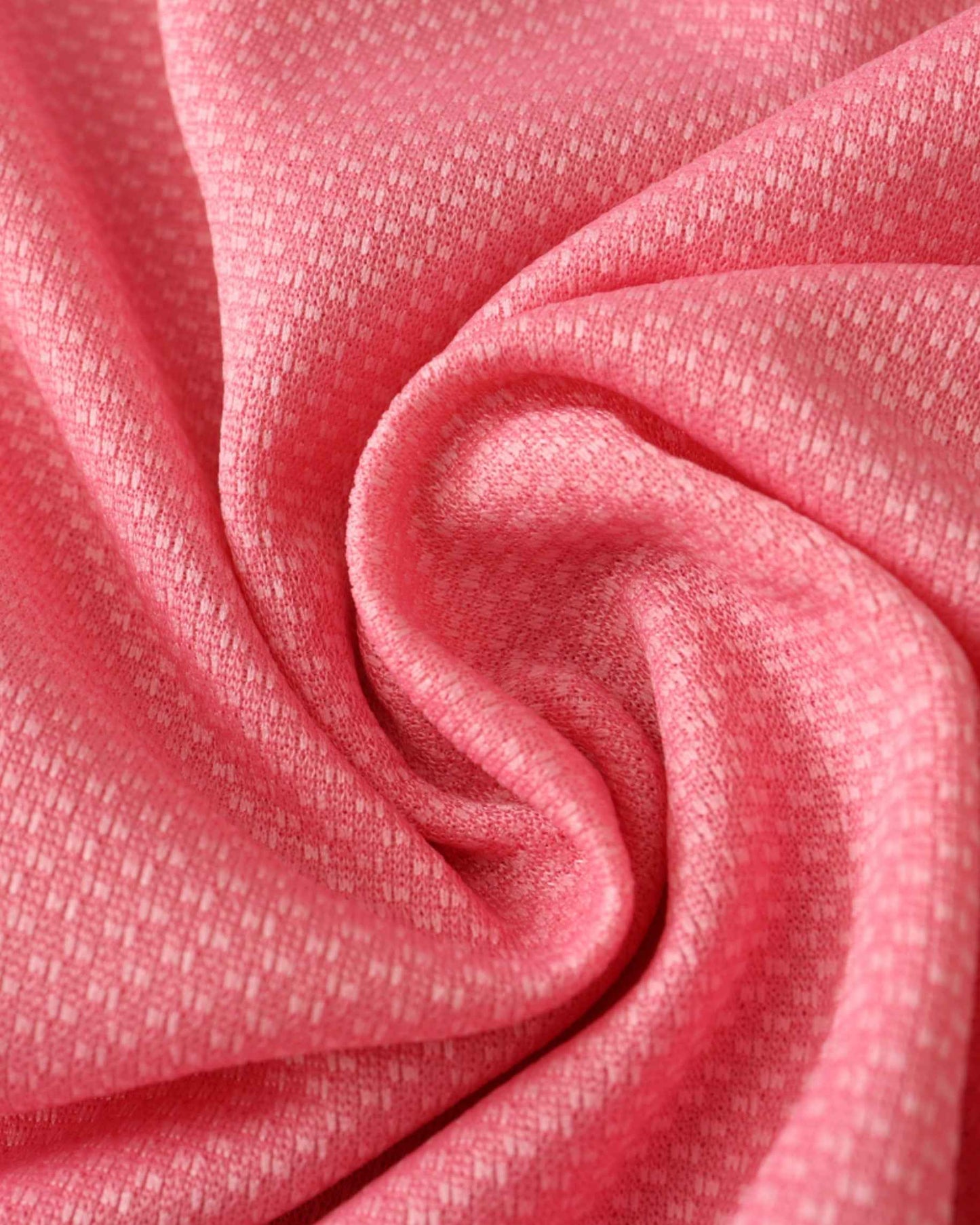 Pink fabric with a subtle textured pattern, draped in soft folds.