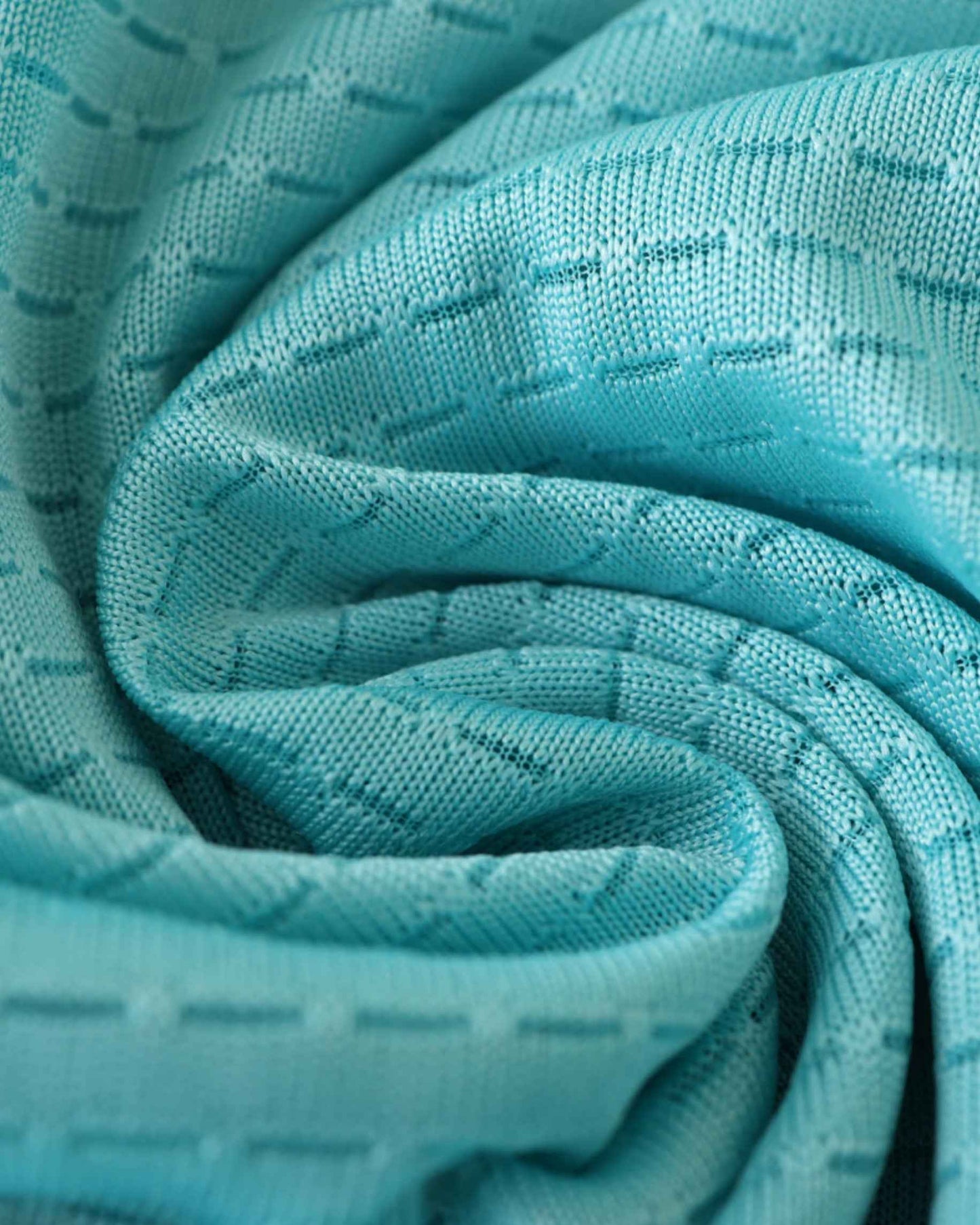 Teal fabric with a subtle geometric pattern, draped and folded.