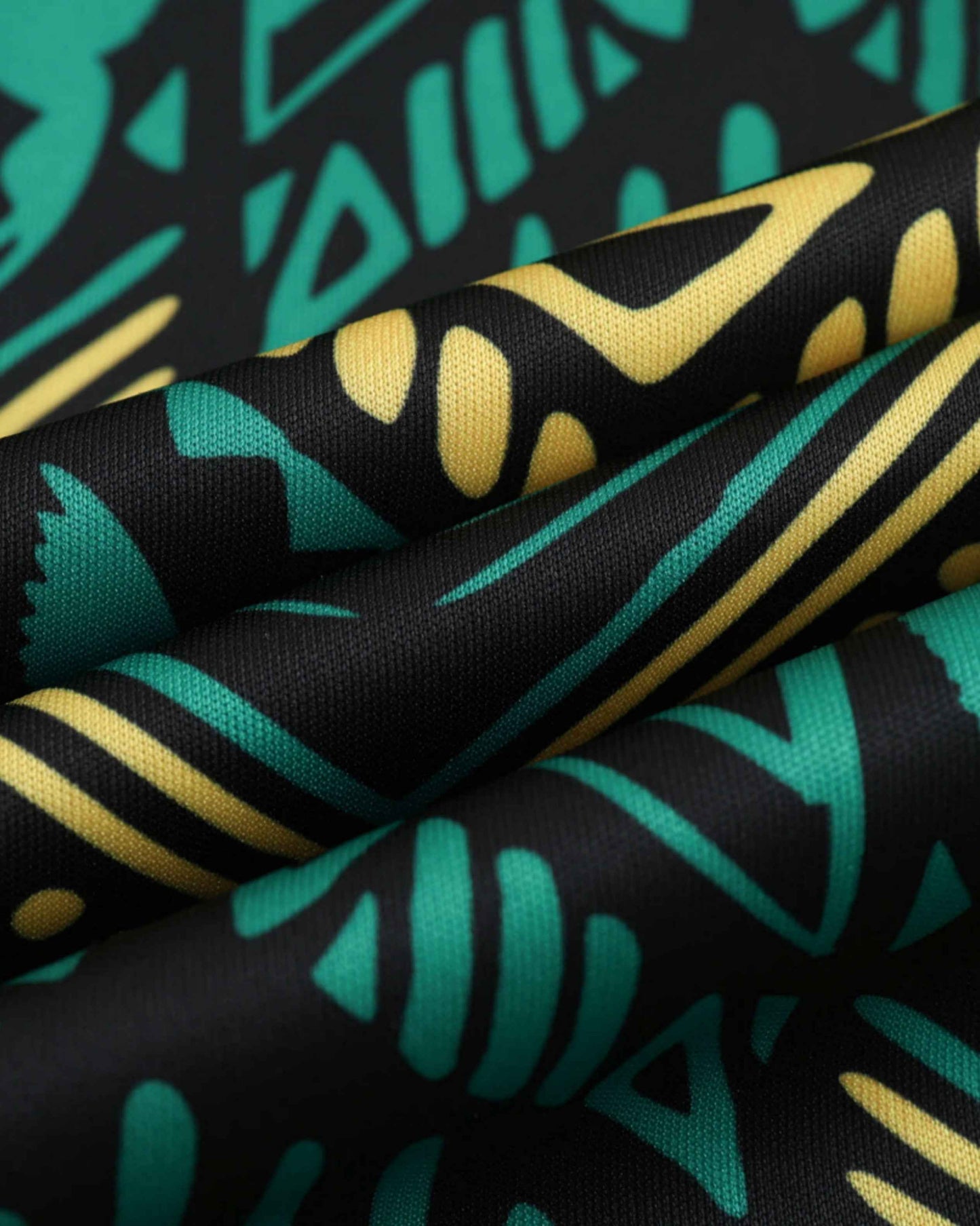Close-up of green and gold tribal print fabric on Jamaica away football jersey 2024/25