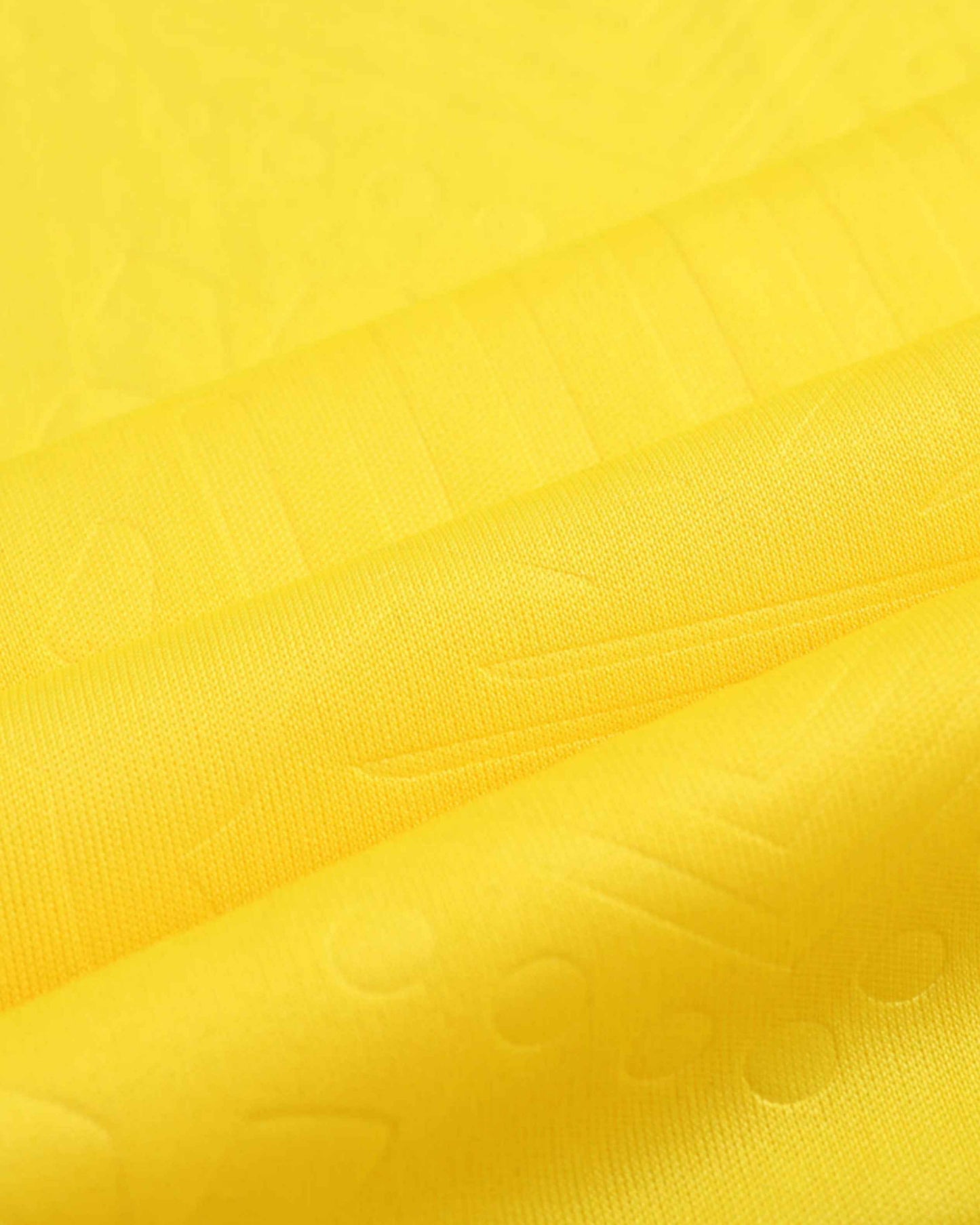 Close-up of the embossed yellow fabric on the Jamaica home 2024/25 jersey