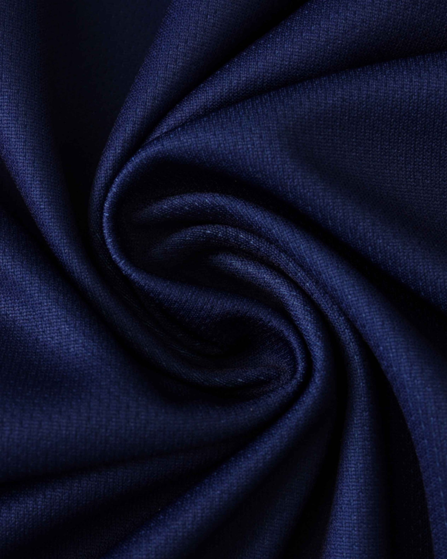 Dark blue fabric with a textured weave, shown in a swirl.