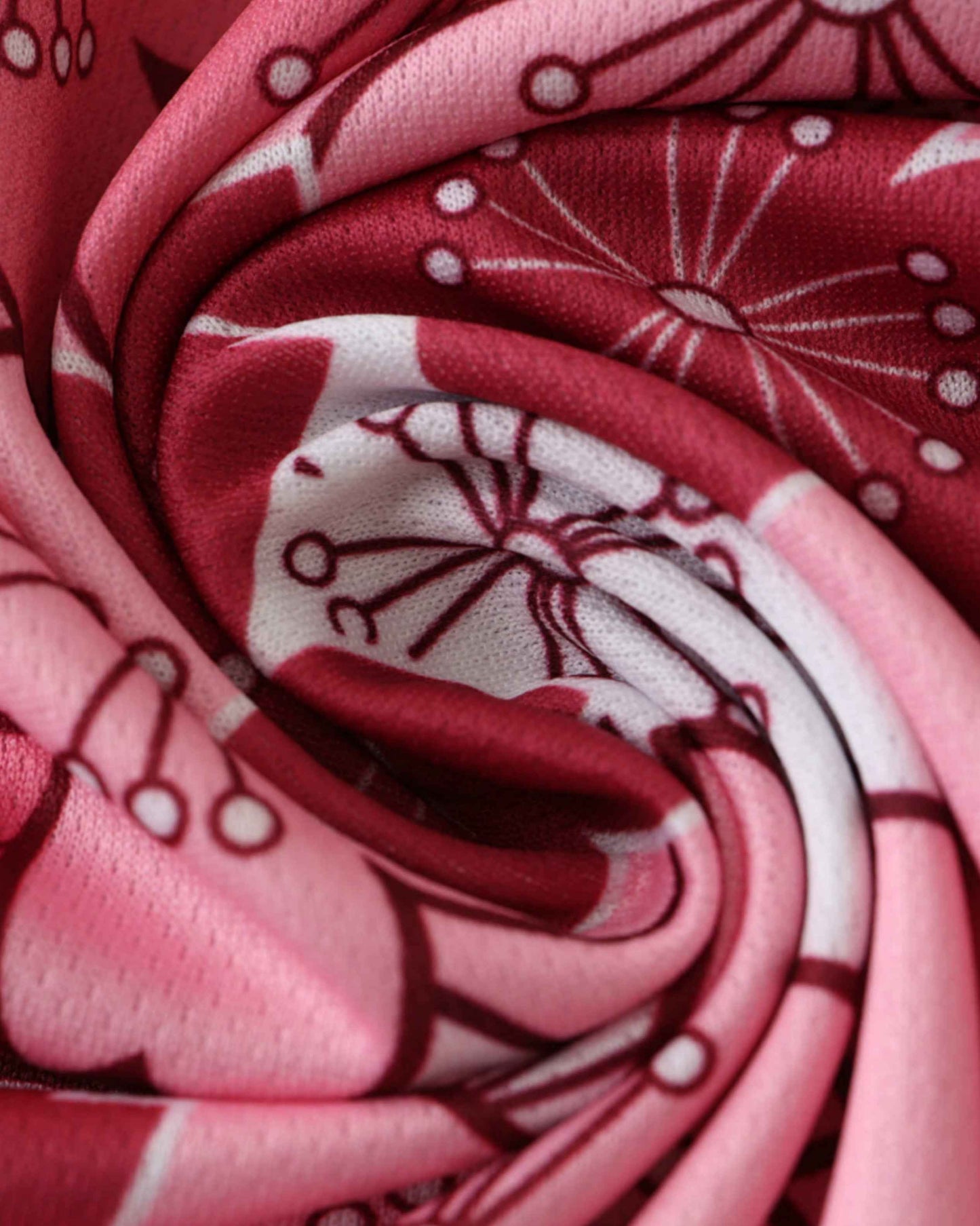 A close-up of pink and red fabric with a cherry blossom pattern.