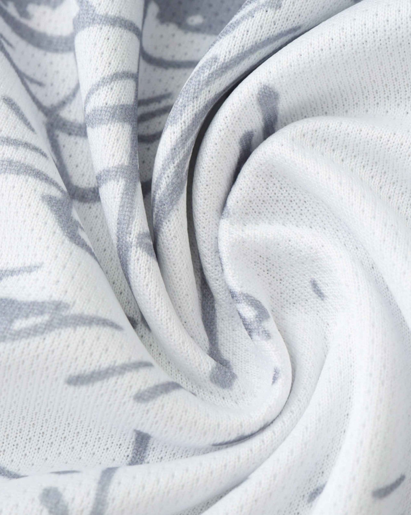 White fabric with a grey pattern, showing folds and texture.