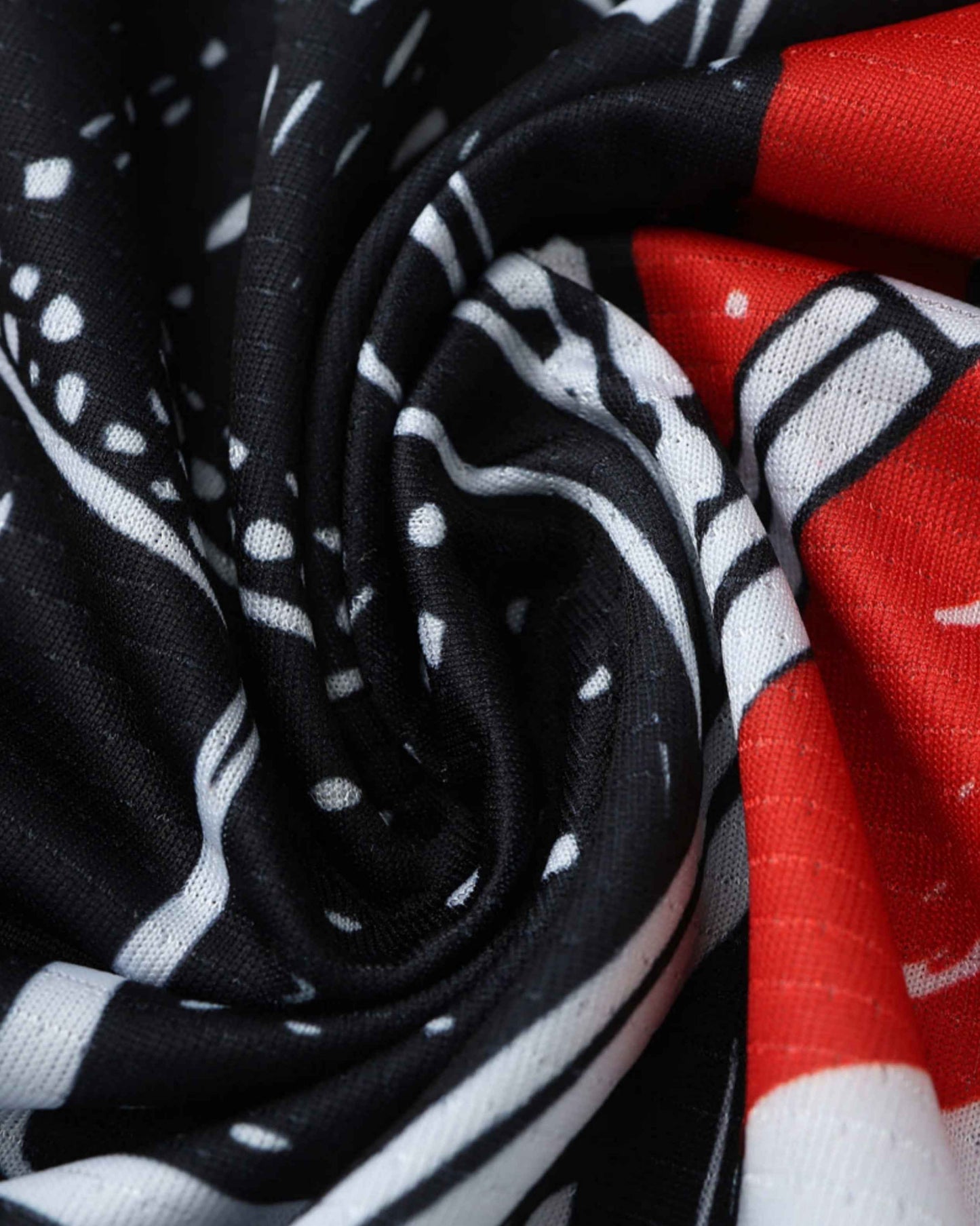 Close-up of a black and white patterned fabric with red accents.