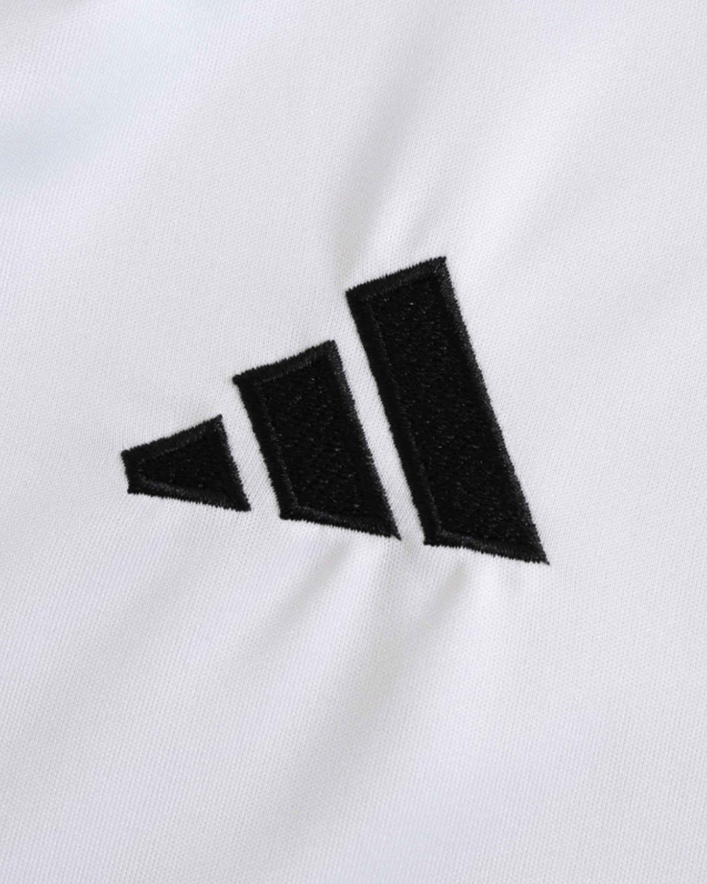Black Adidas logo embroidered on a white fabric.
