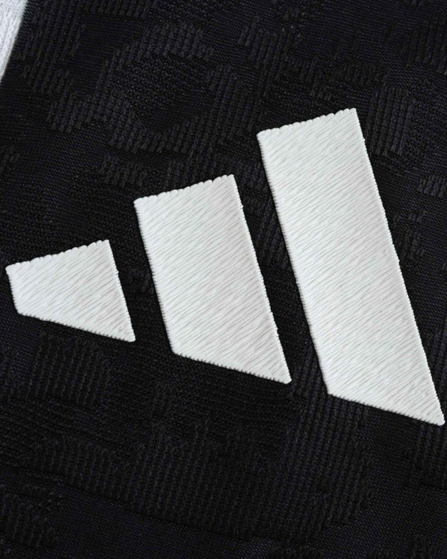 Juventus home football jersey 2024/25 fabric close-up with three white Adidas stripes on black
