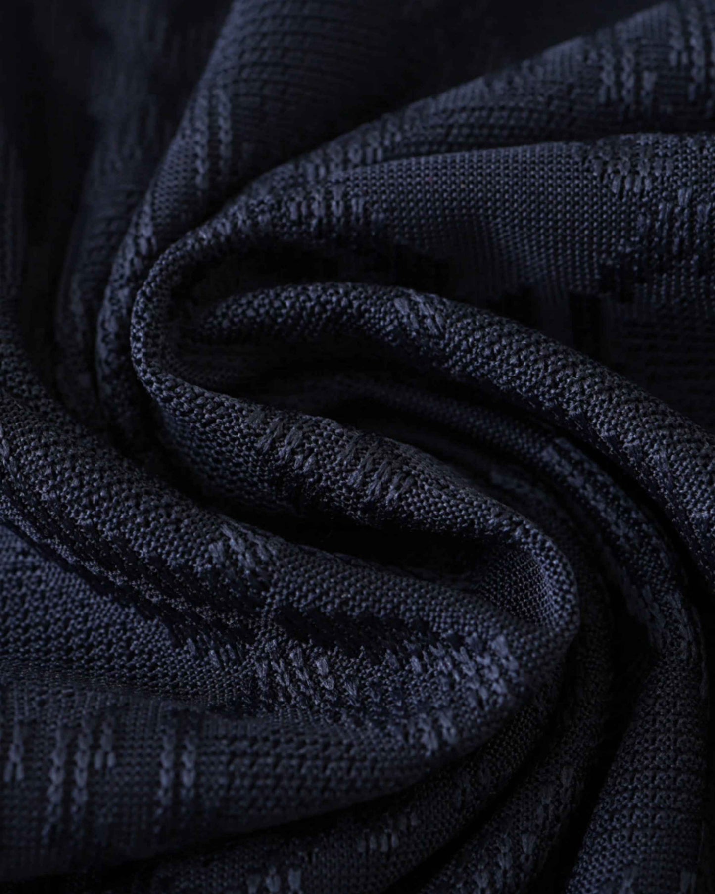 Dark blue textured fabric with a subtle pattern, likely a football jersey.