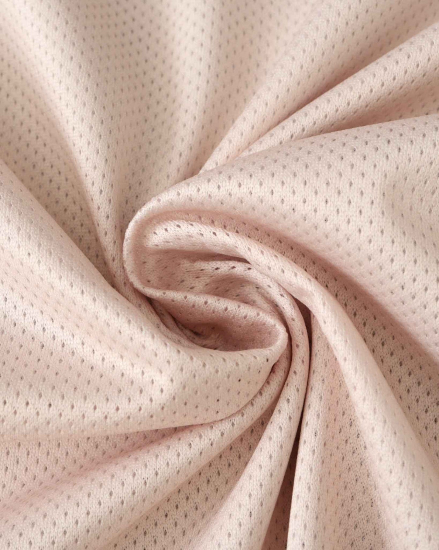 A close-up of a pink, perforated fabric with a soft sheen.