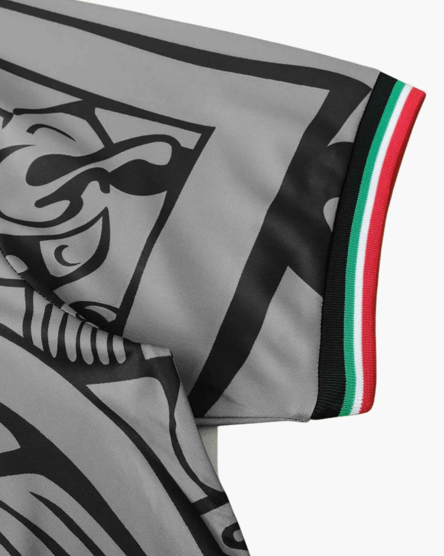 A grey football jersey with black graphic details and a tricolor trim on the sleeve.