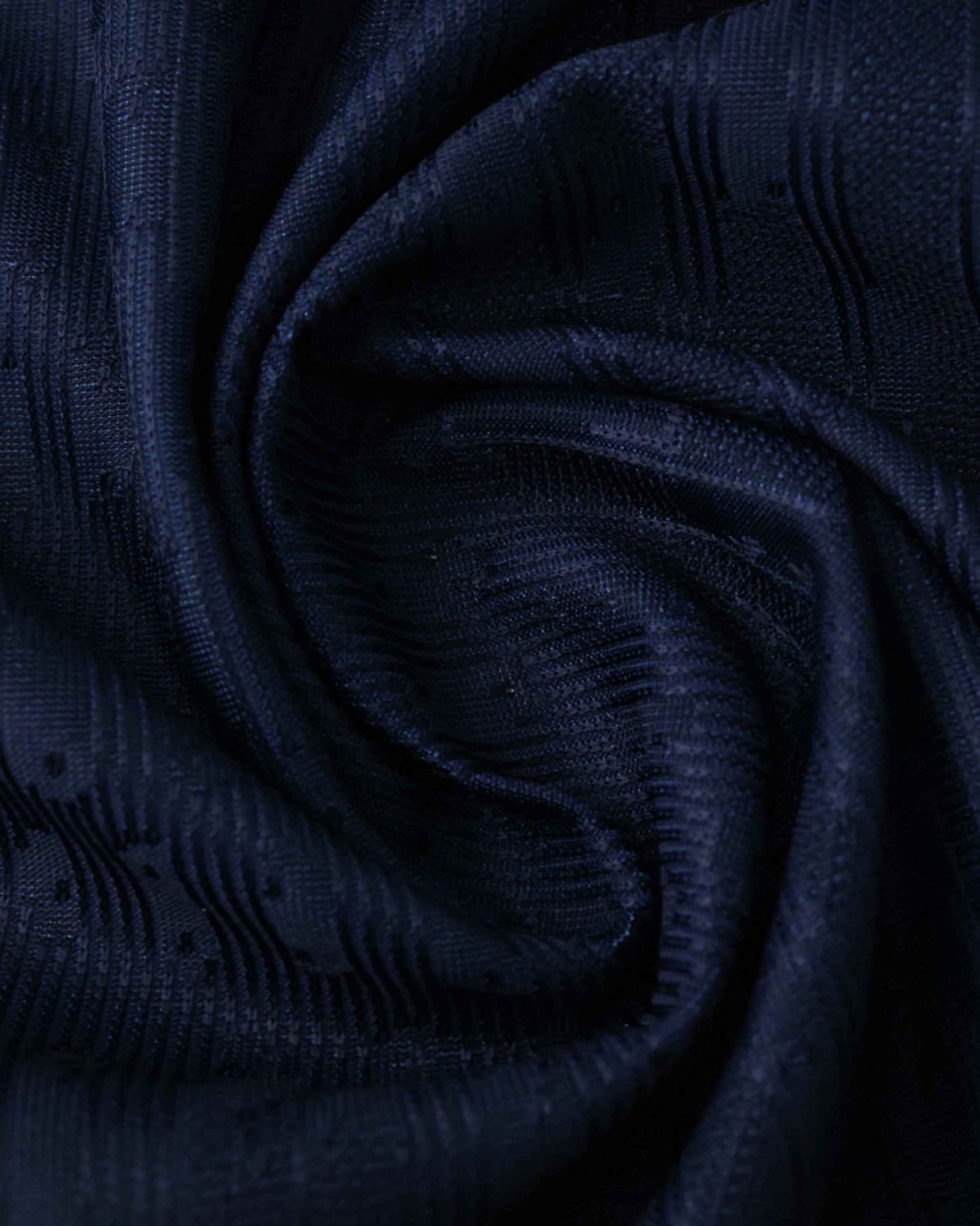 Dark blue textured fabric with a subtle pattern.