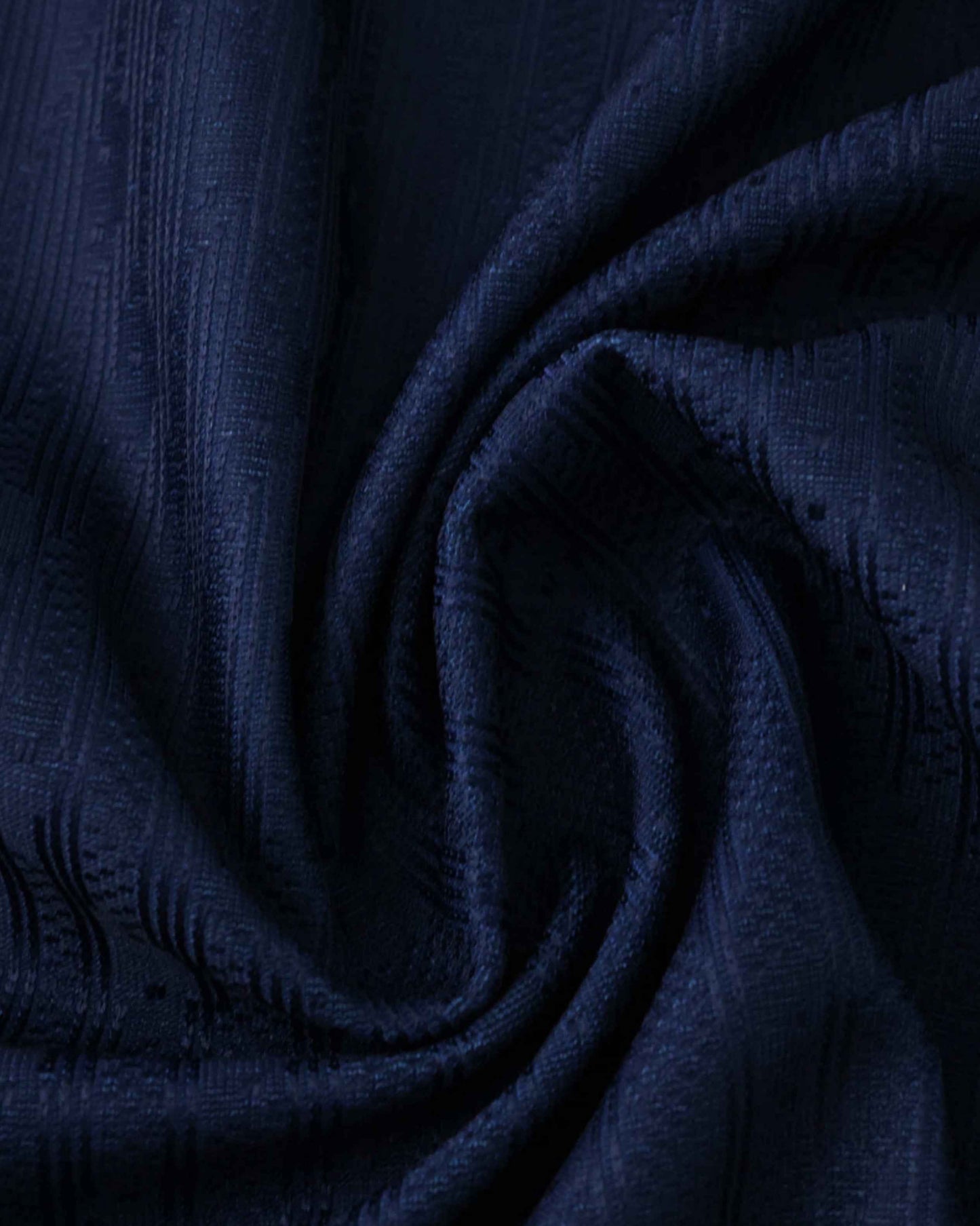 Dark blue fabric with a textured pattern, draped in folds.