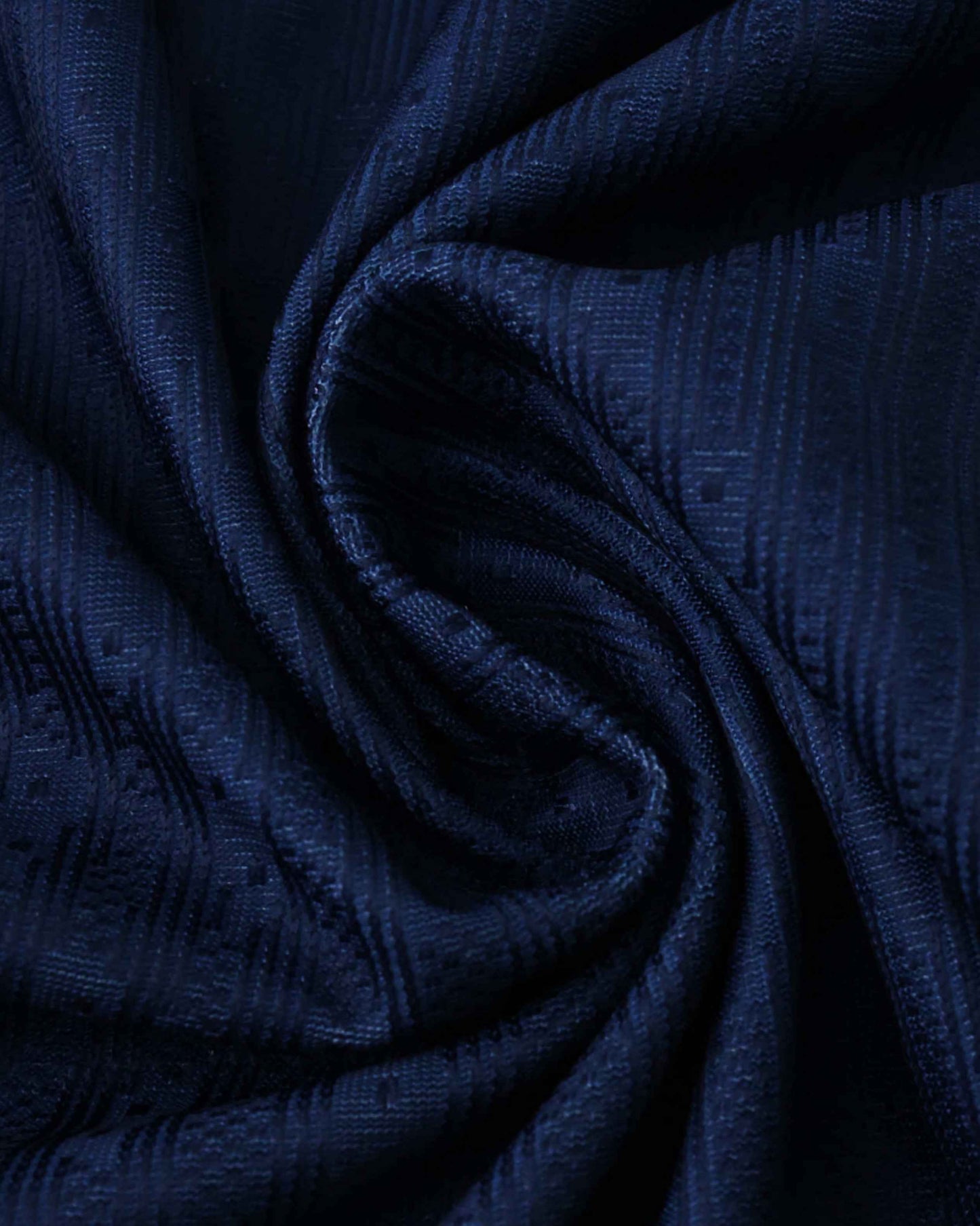 Dark blue textured fabric with a subtle geometric pattern.