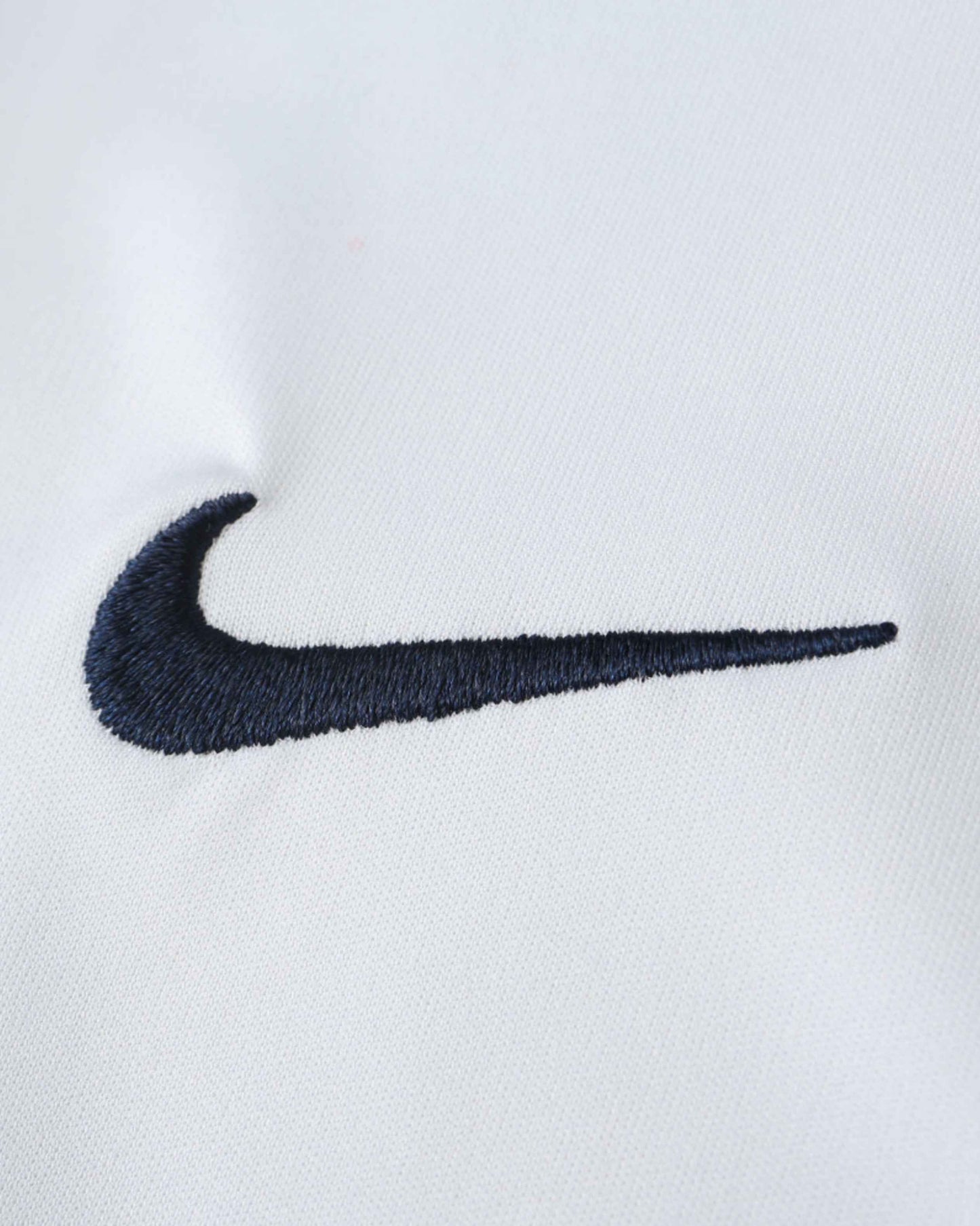 White football jersey with an embroidered navy Nike swoosh.