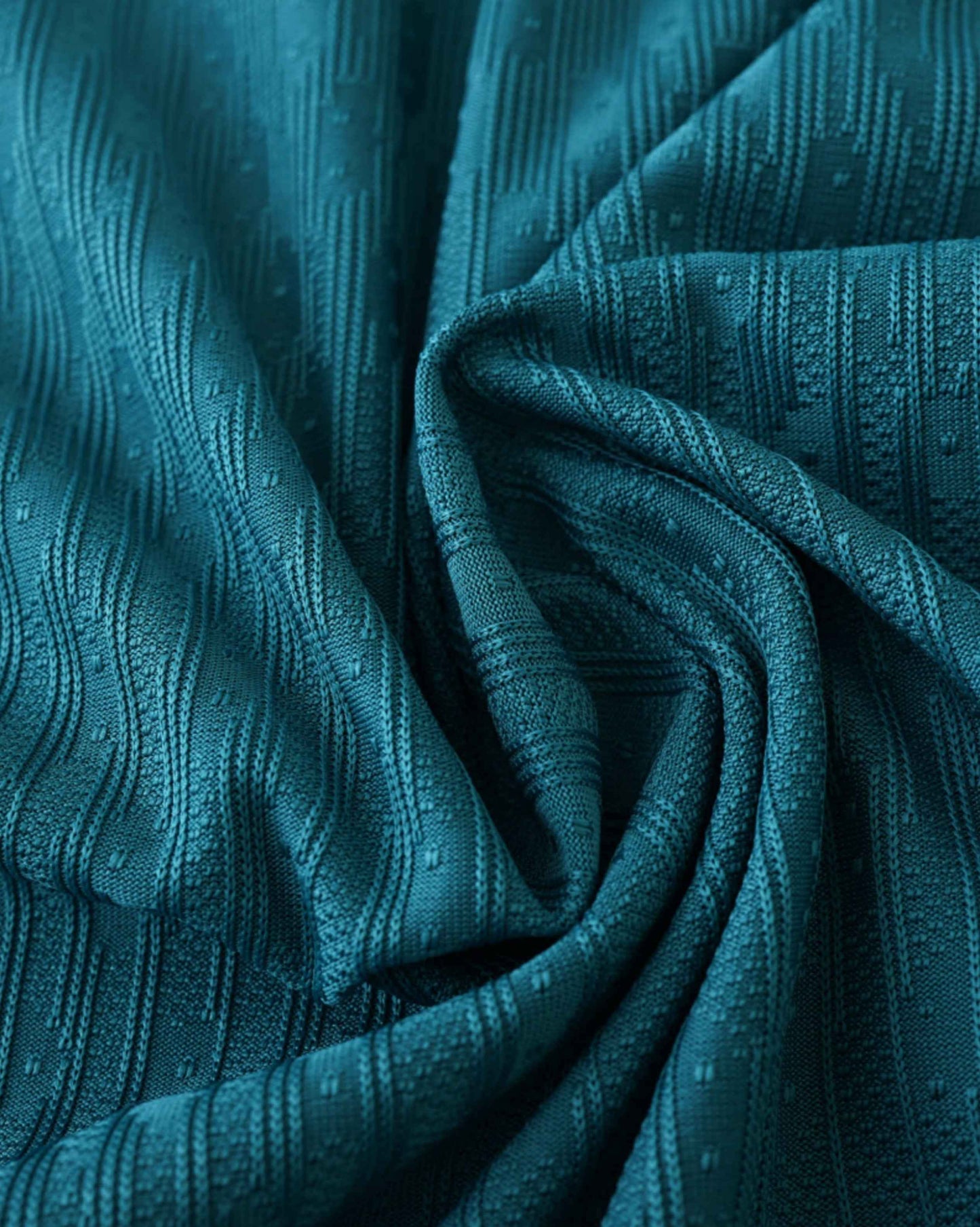 Teal fabric with a textured pattern of vertical lines and small dots.