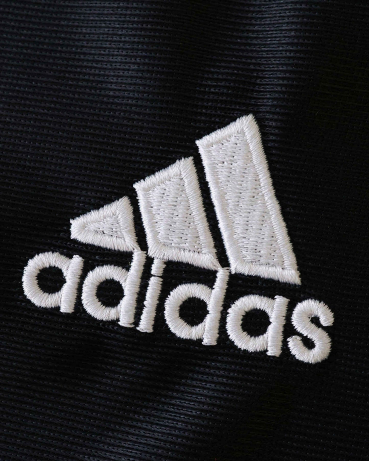 White adidas logo on black fabric of Real Madrid 1999/2000 retro away kids football jersey