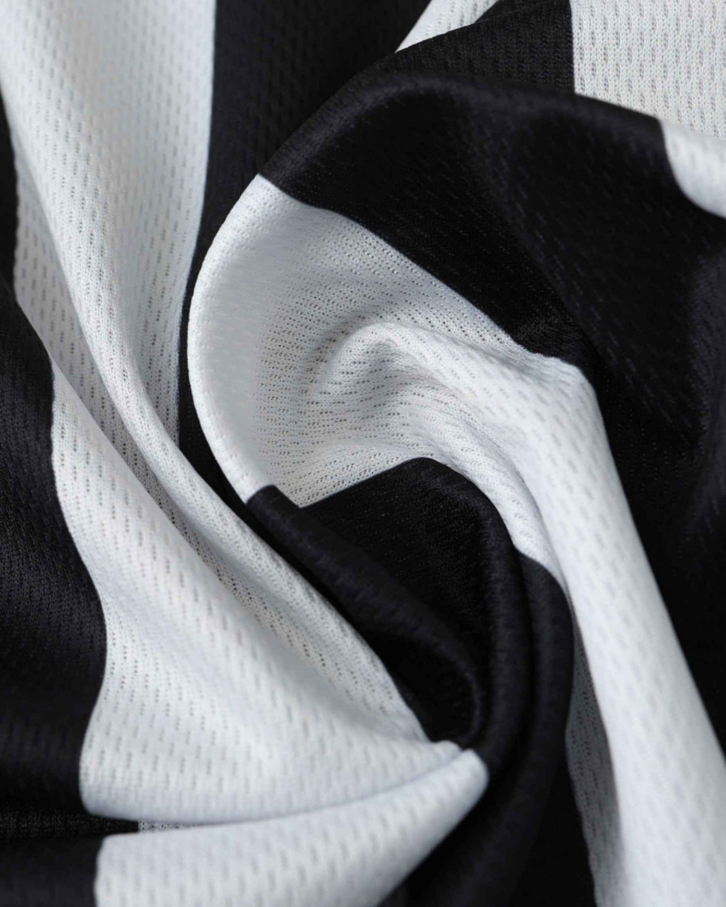 Close-up of a black and white striped fabric with a mesh texture.