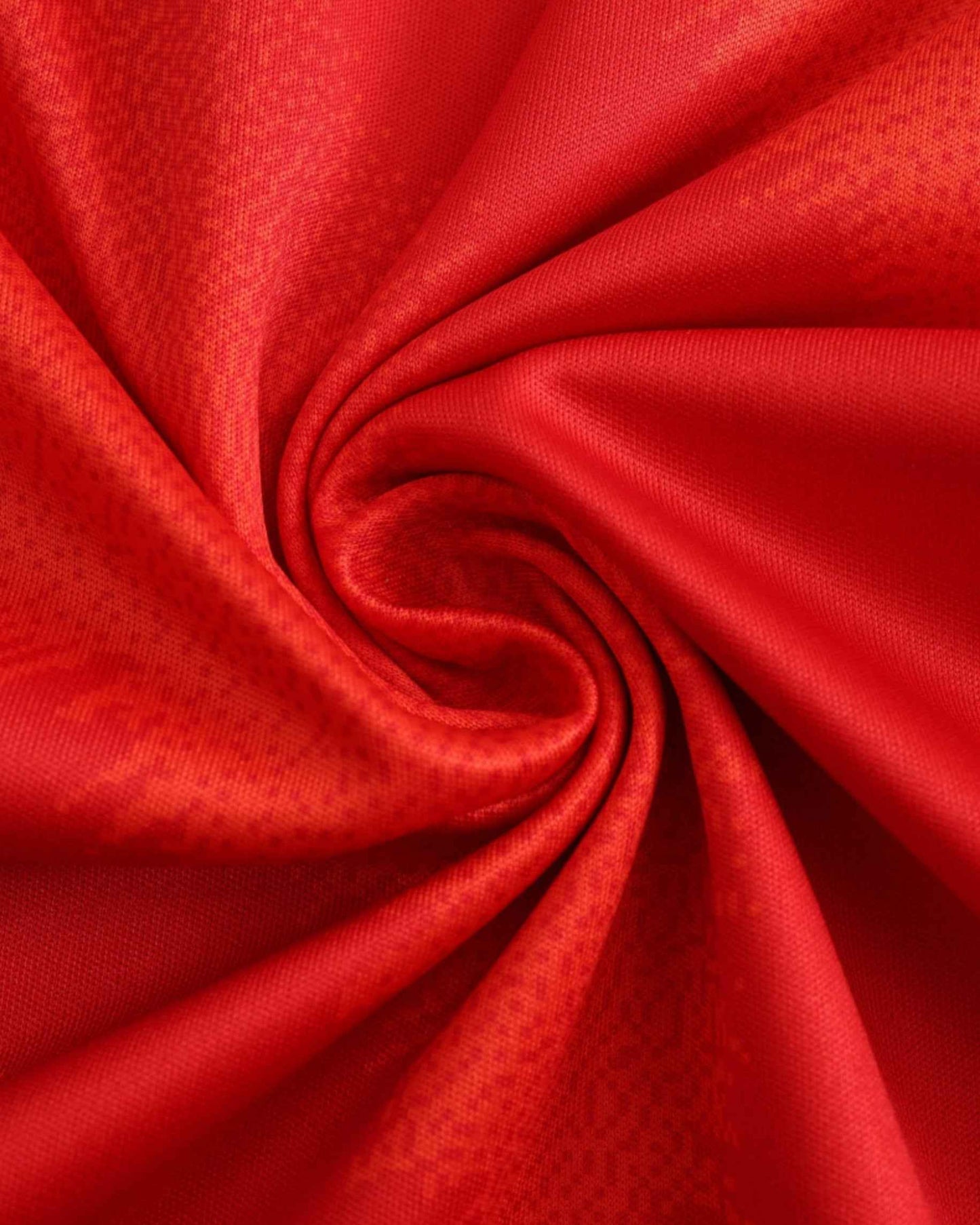 Red textured swirl fabric close-up of the Spain UEFA home football jersey 2024/25