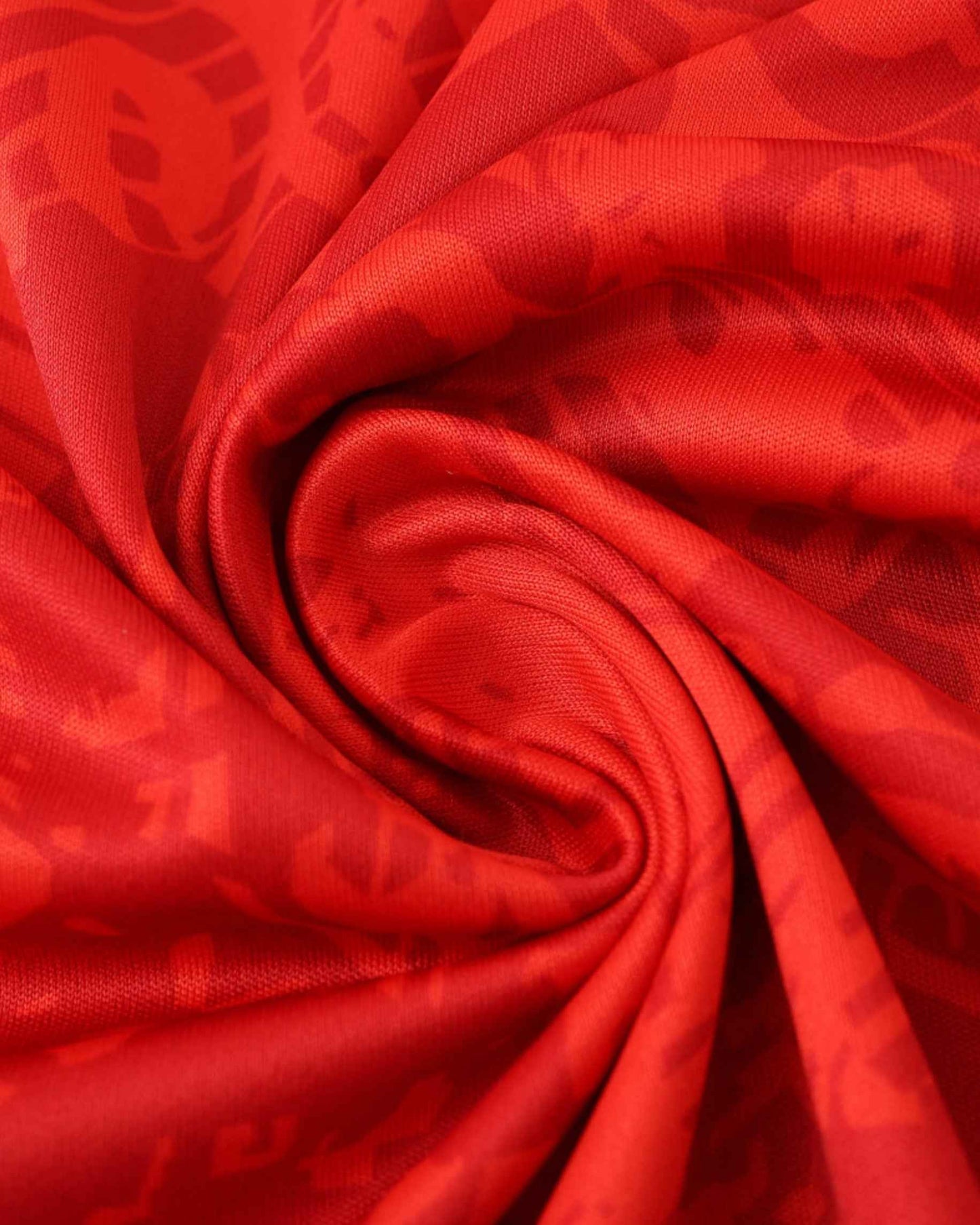 Red fabric with a subtle pattern, draped in folds.